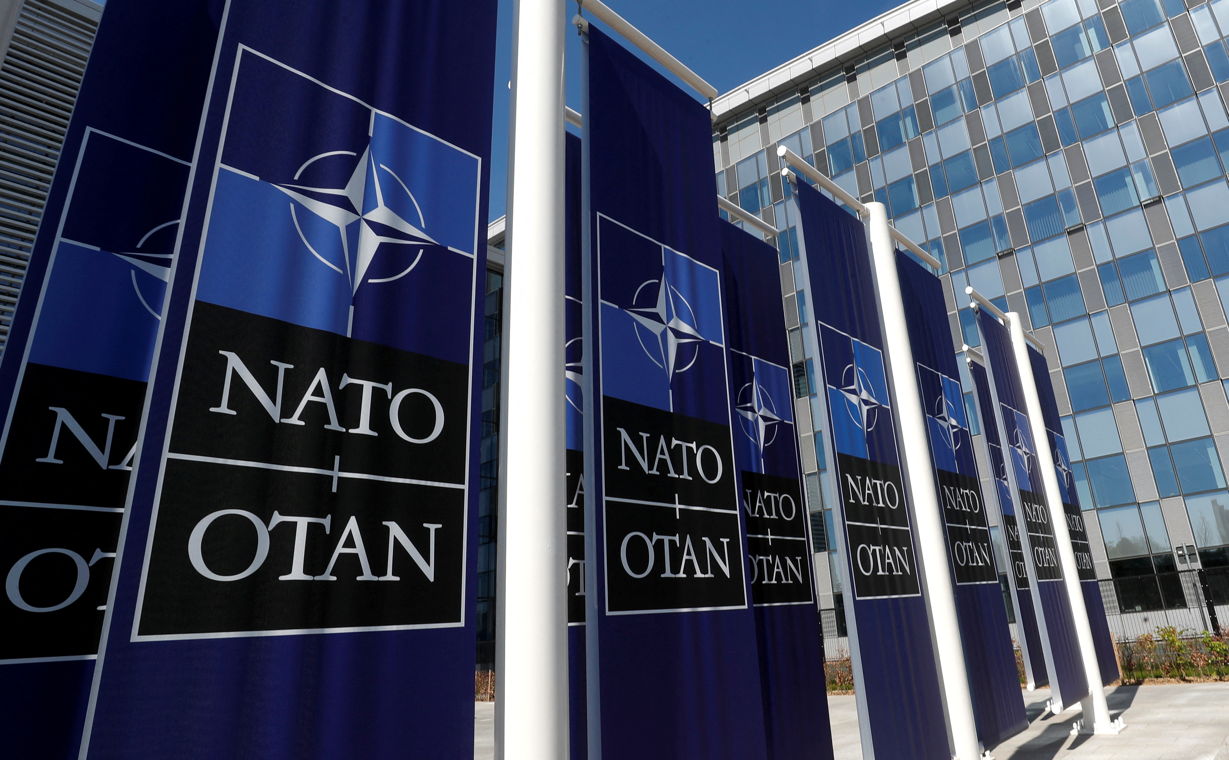 Naton logolla varustetut bannerit sijoitetaan Naton uuden päämajan sisäänkäynnille uuteen rakennukseen muuton aikana