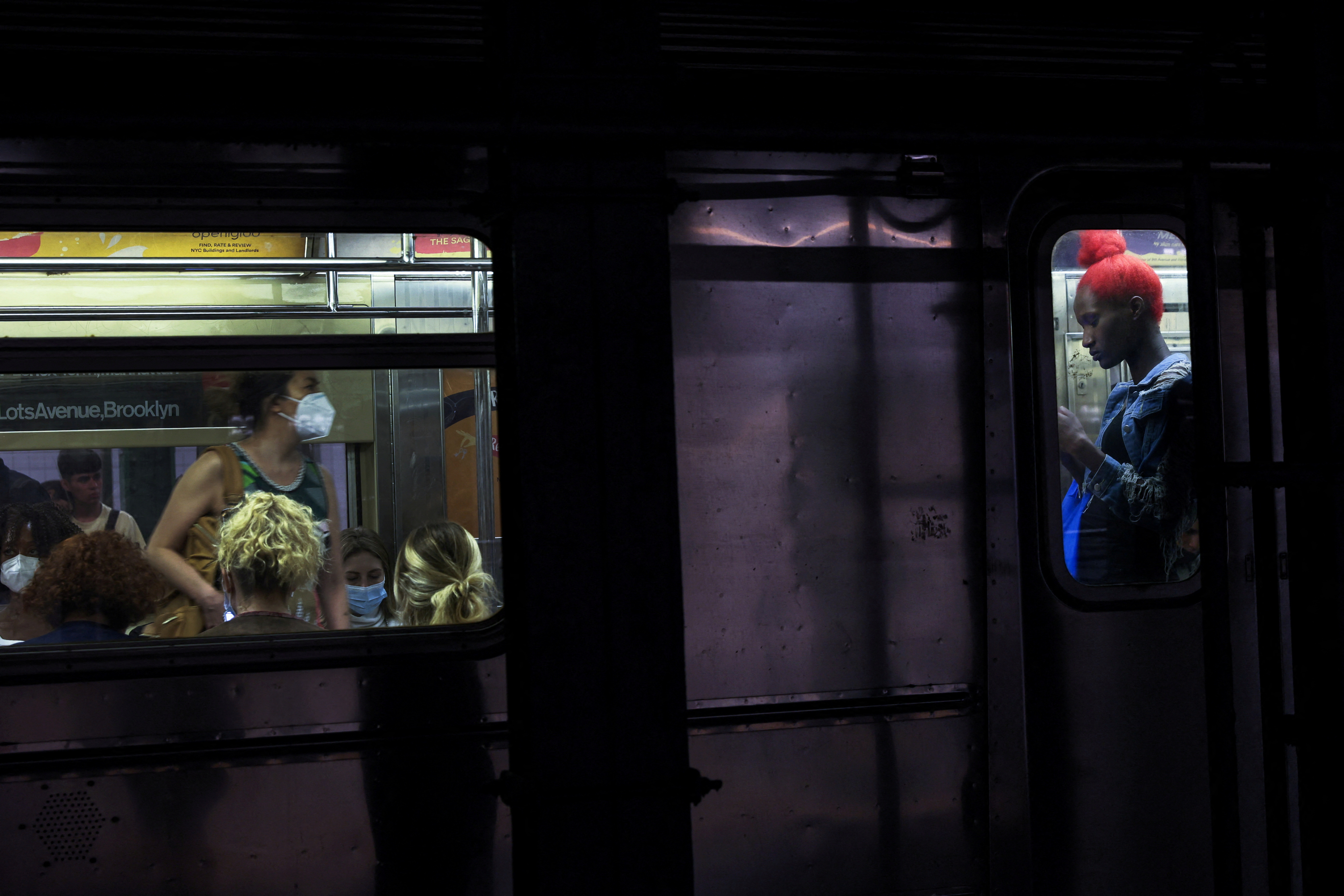 People are seen on board a subway at the 42nd street station in New York City