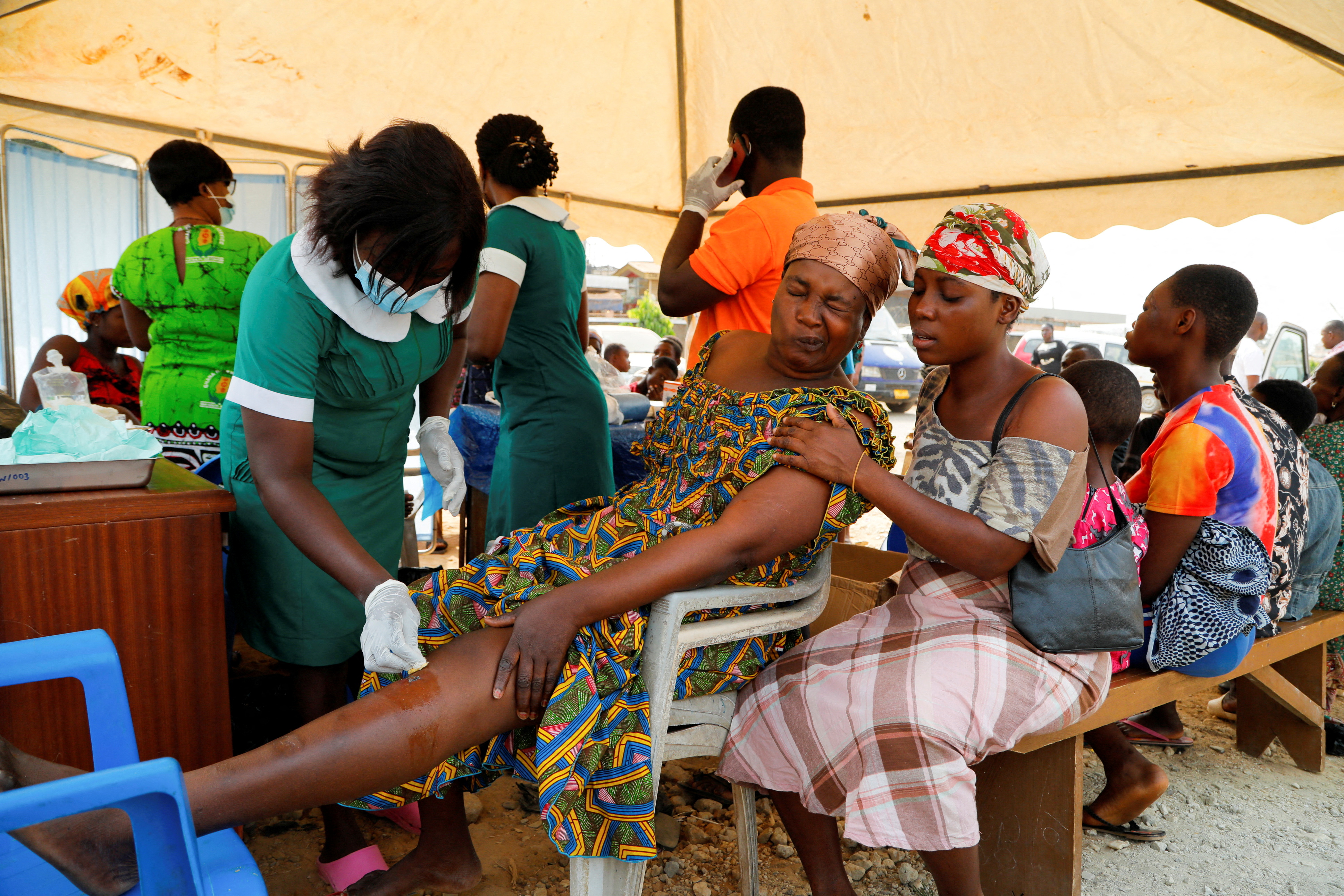 Nancy Nyarko, 51, a street vendor, receives medical attention for wounds suffered when a vehicle carrying mining explosives detonated along a road in Apiate, Bogoso