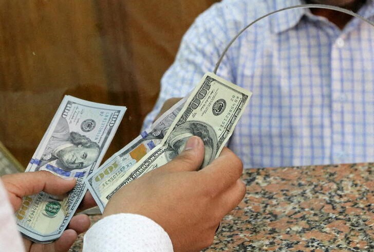 A customer exchanges U.S. dollars to Egyptian pounds in a foreign exchange office in central Cairo, Egypt