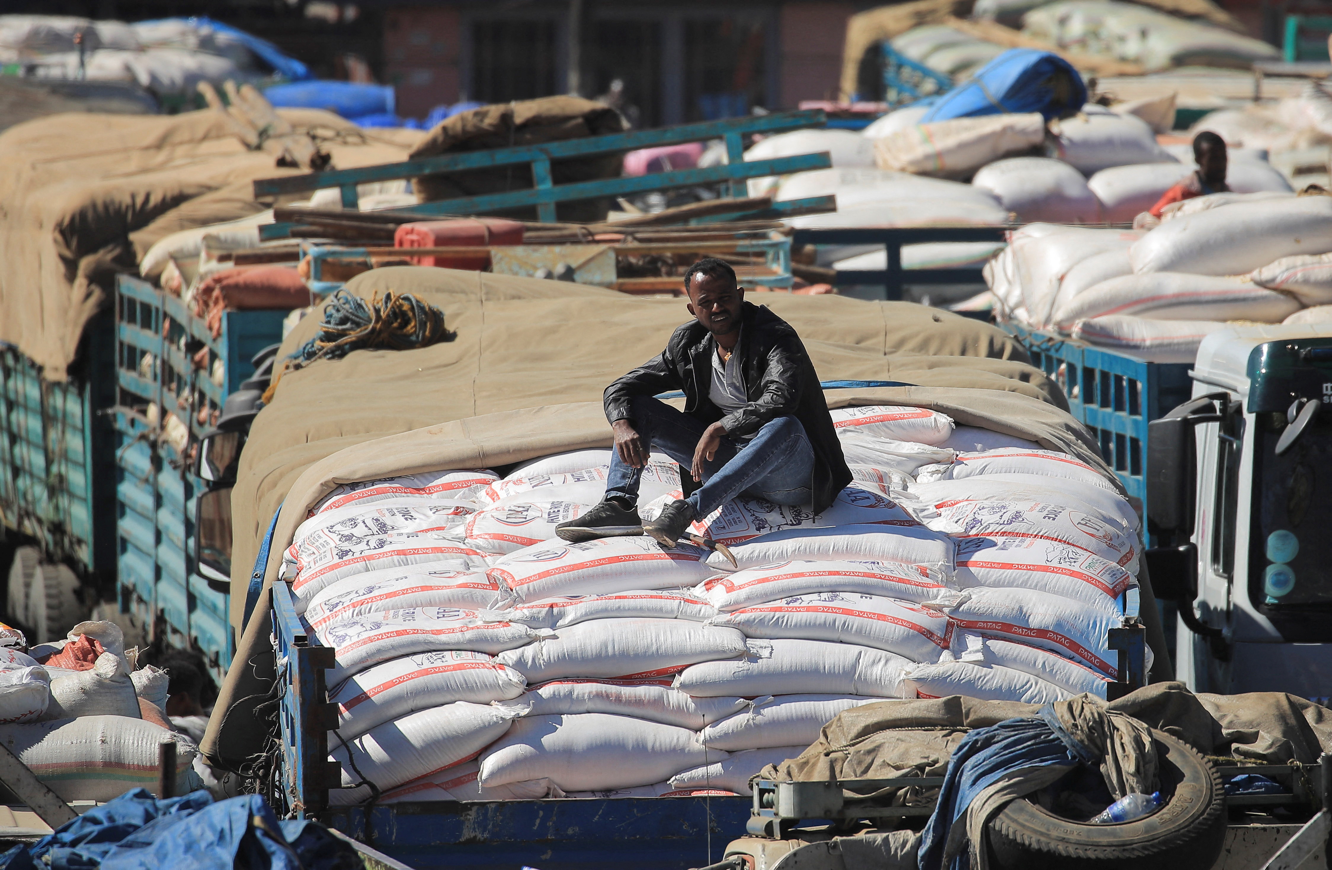 Labourer sits atop a truck queuing with sacks of grains at the grain market in Merkato neighbourhood of Addis Ababa