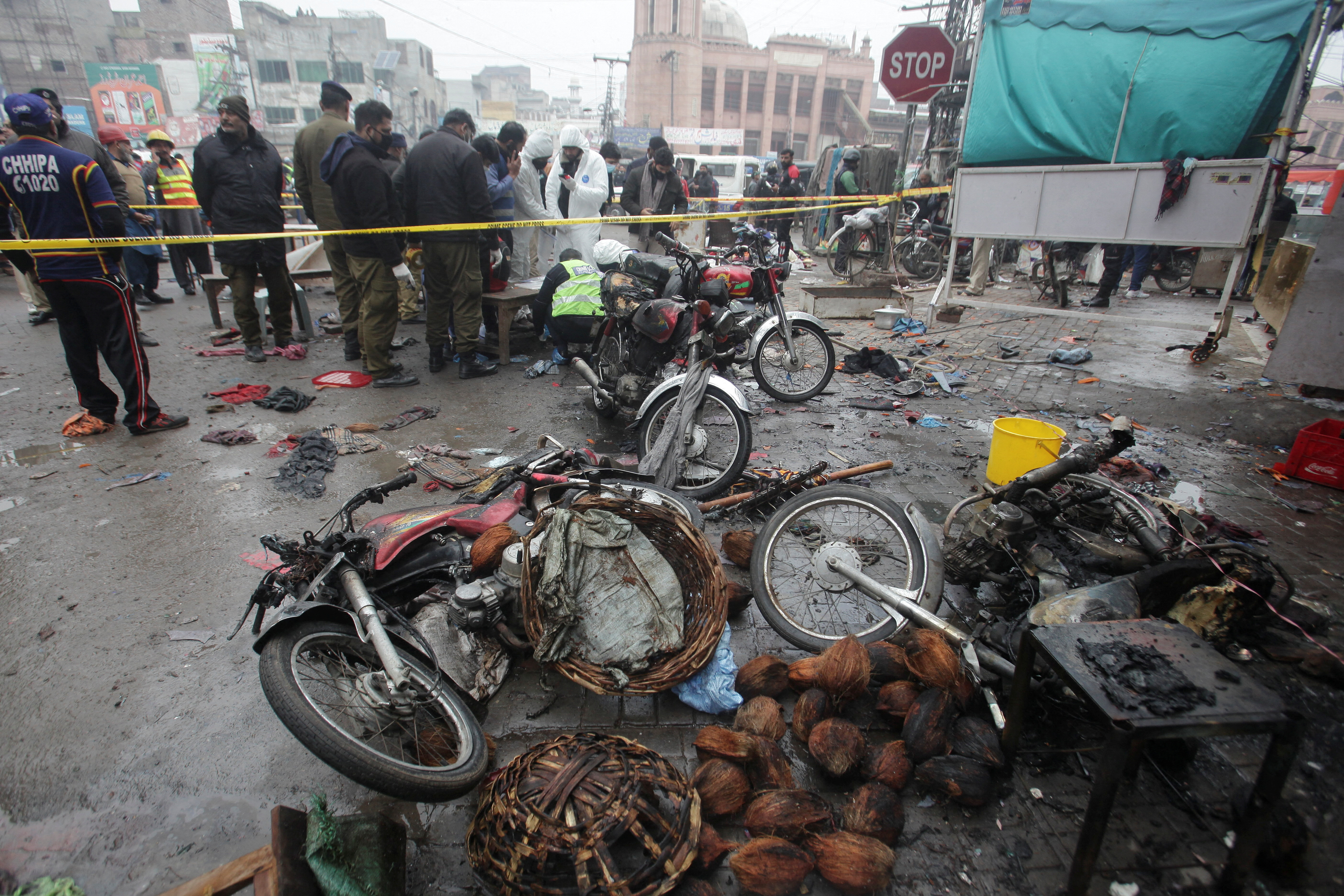 Members of crime scene unit and bomb disposal team gather after a blast in Lahore