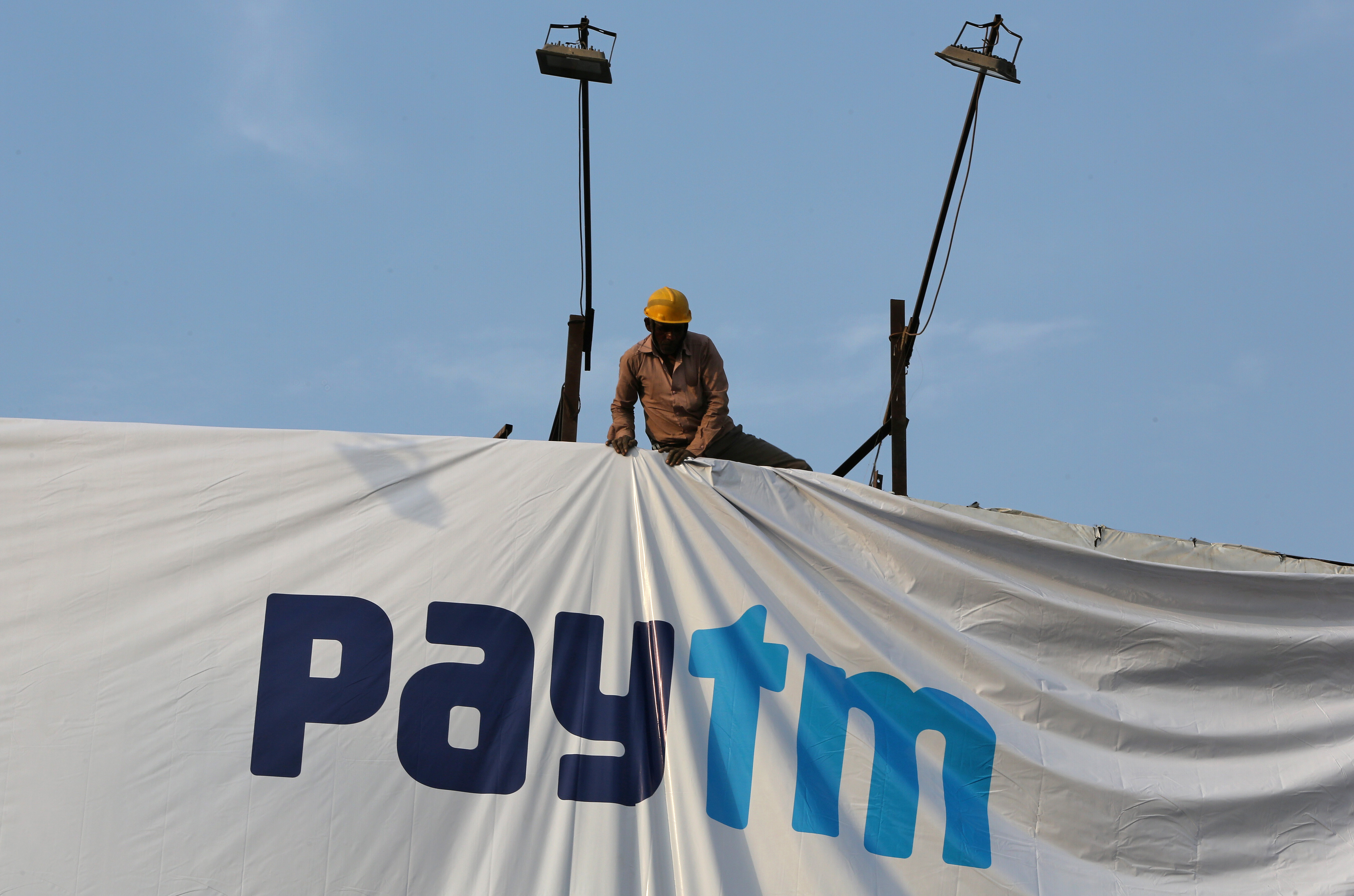 A worker adjusts a hoarding of Paytm, a digital payments firm, in Ahmedabad, India, January 31, 2019. Picture taken January 31, 2019. REUTERS/Amit Dave - RC1C2463DEA0