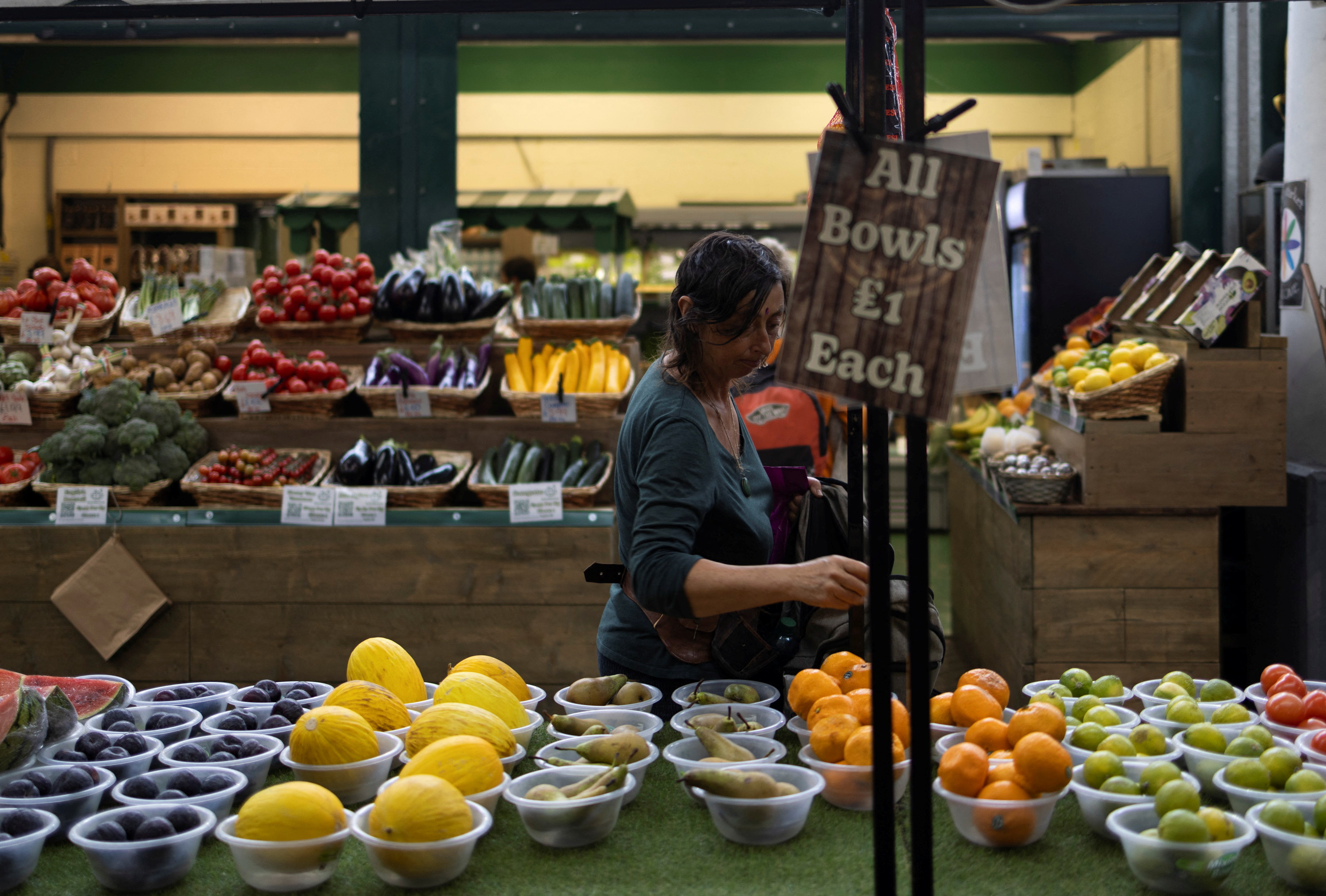 A woman buys fruits and vegetables at the local market in Brighton