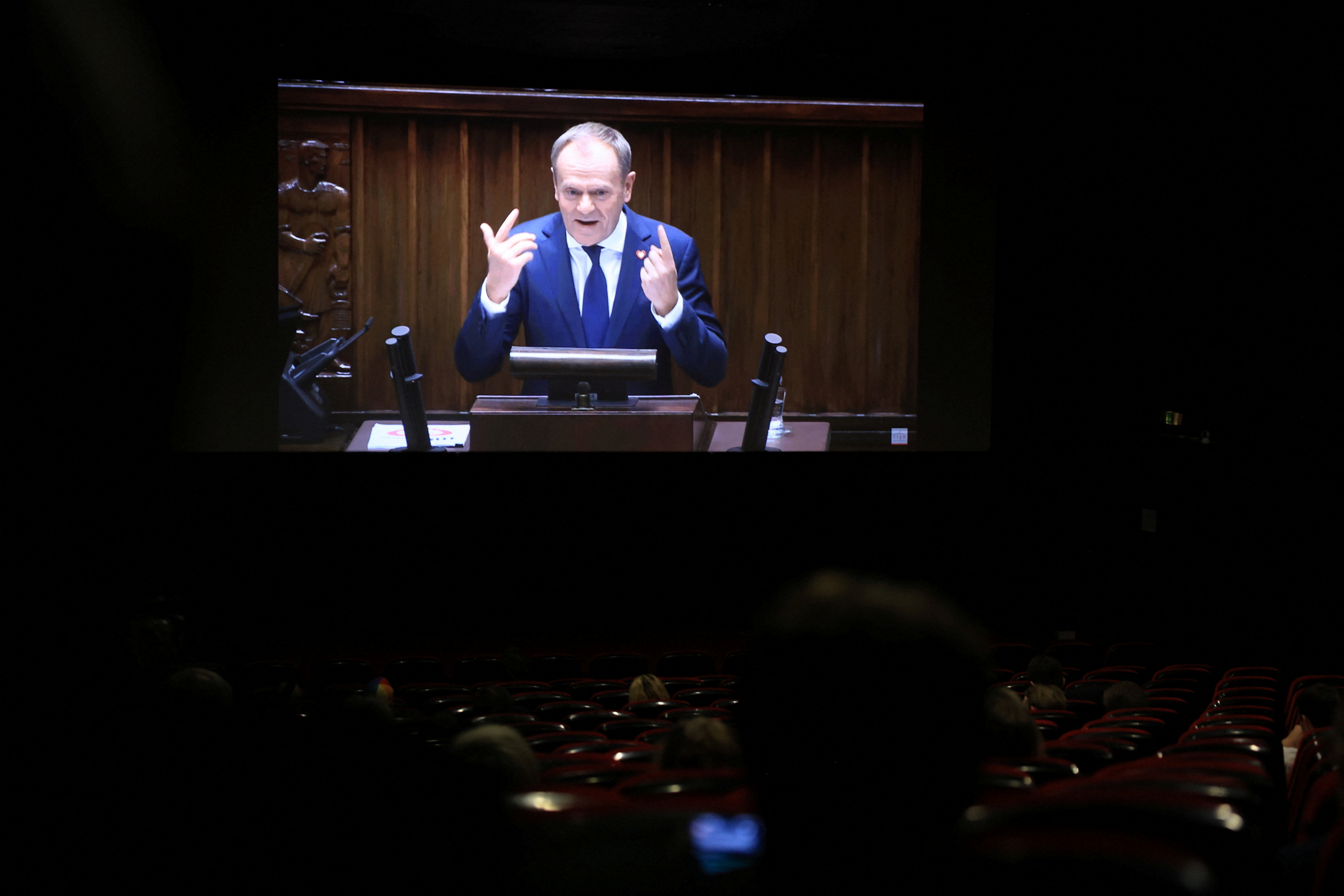 Newly appointed Polish Prime Minister Donald Tusk presenting his government's programme in Parliament is displayed on the screen at the cinema in Warsaw