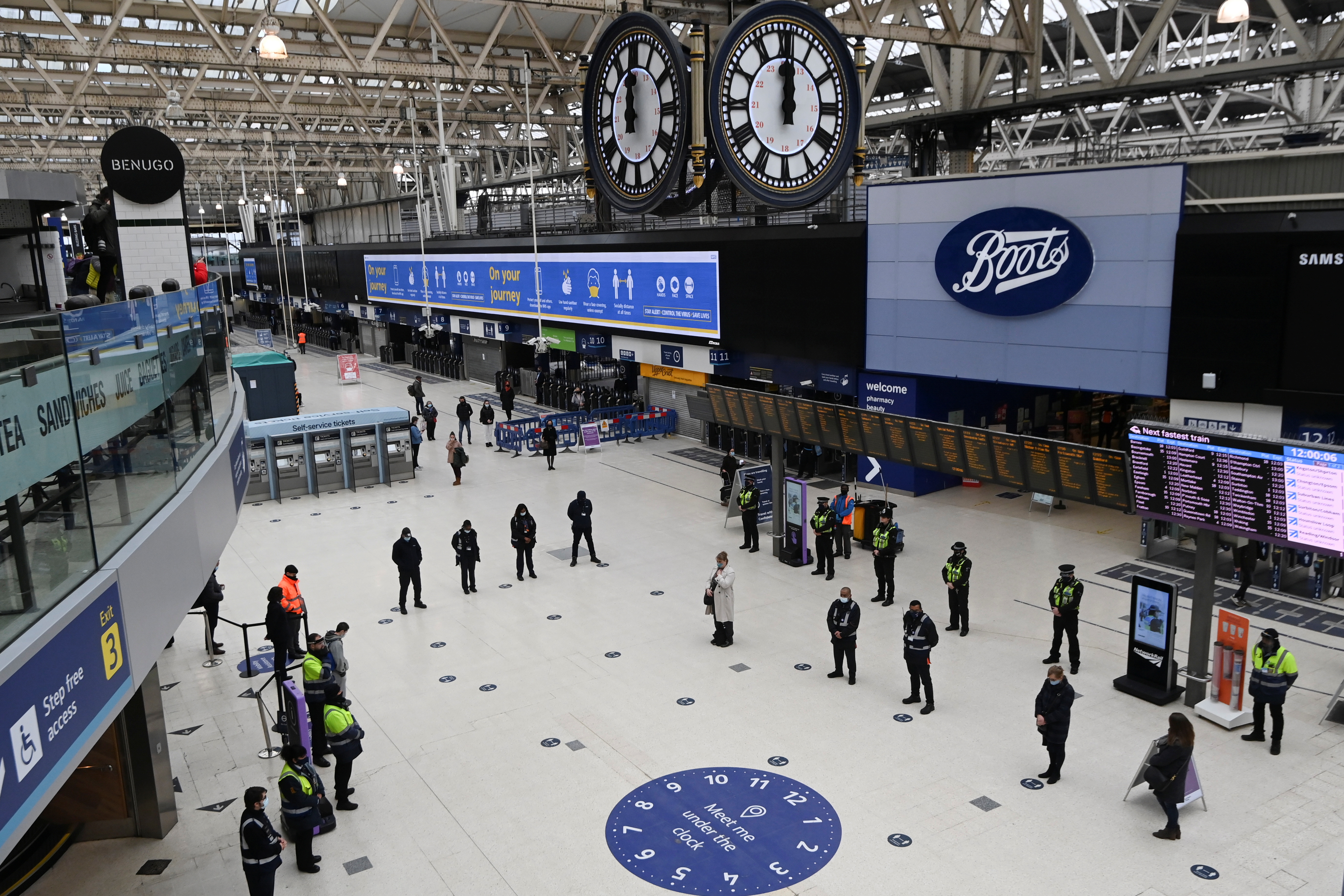 Travellers and workers stand for a minute of silence during the day of reflection to mark the anniversary of Britain's first coronavirus disease (COVID-19) lockdown, at Waterloo station in London, Britain, March 23, 2021. REUTERS/Toby Melville