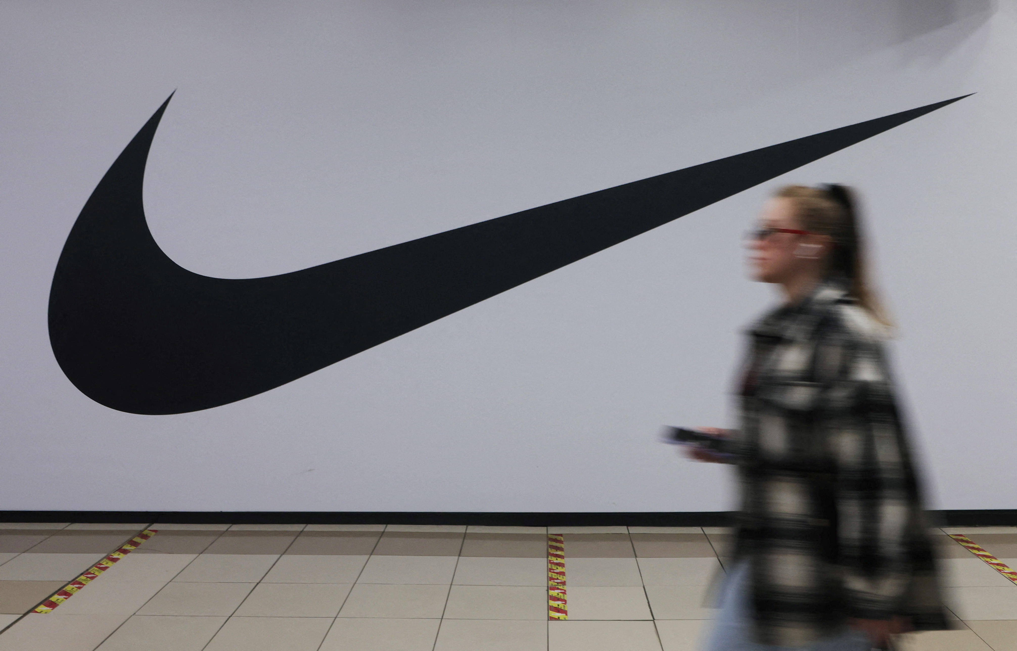 A woman walks past a closed store of Nike in Saint Petersburg