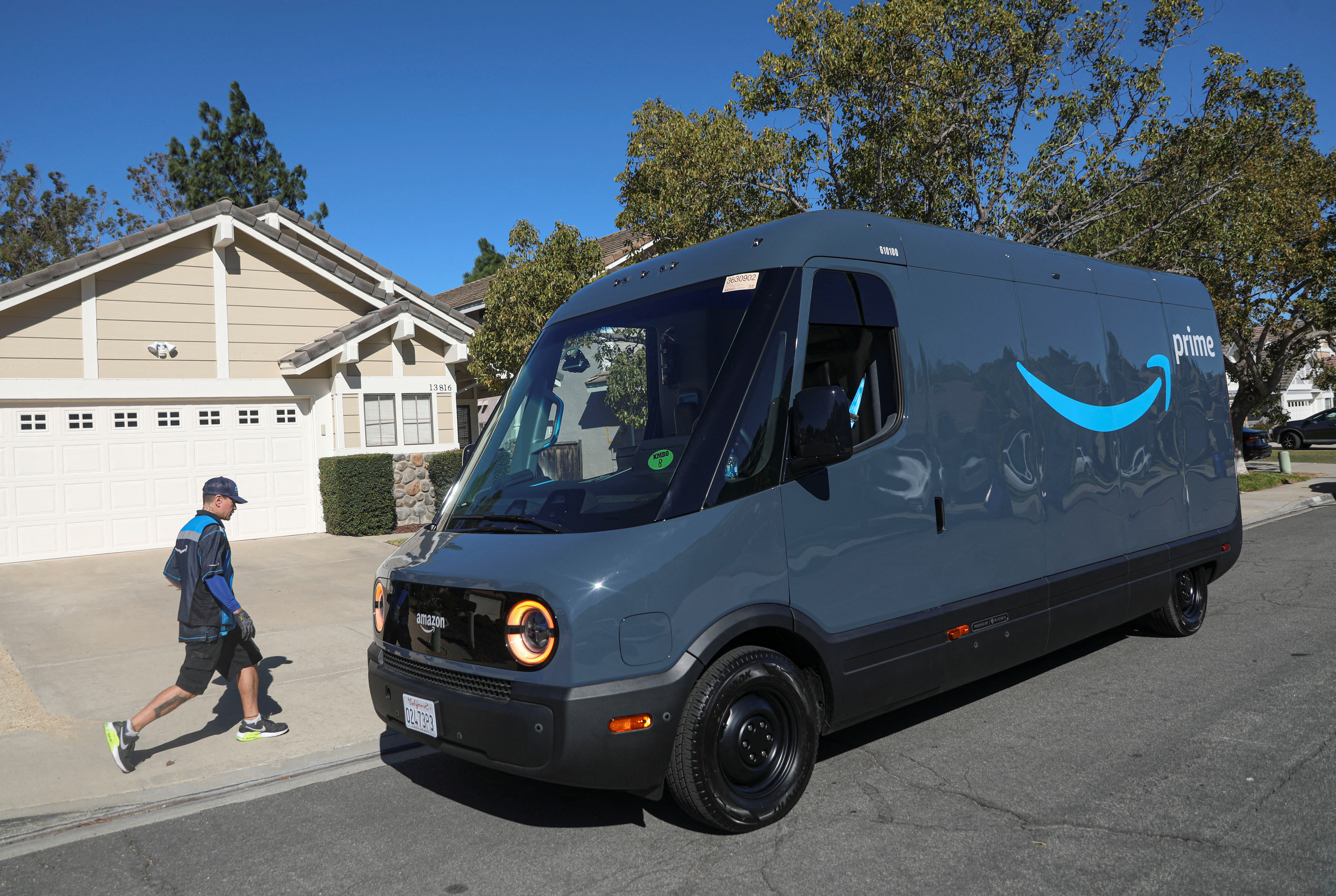 A delivery driver on his rounds in an Amazon Rivian Electric truck in Poway, California, U.S.