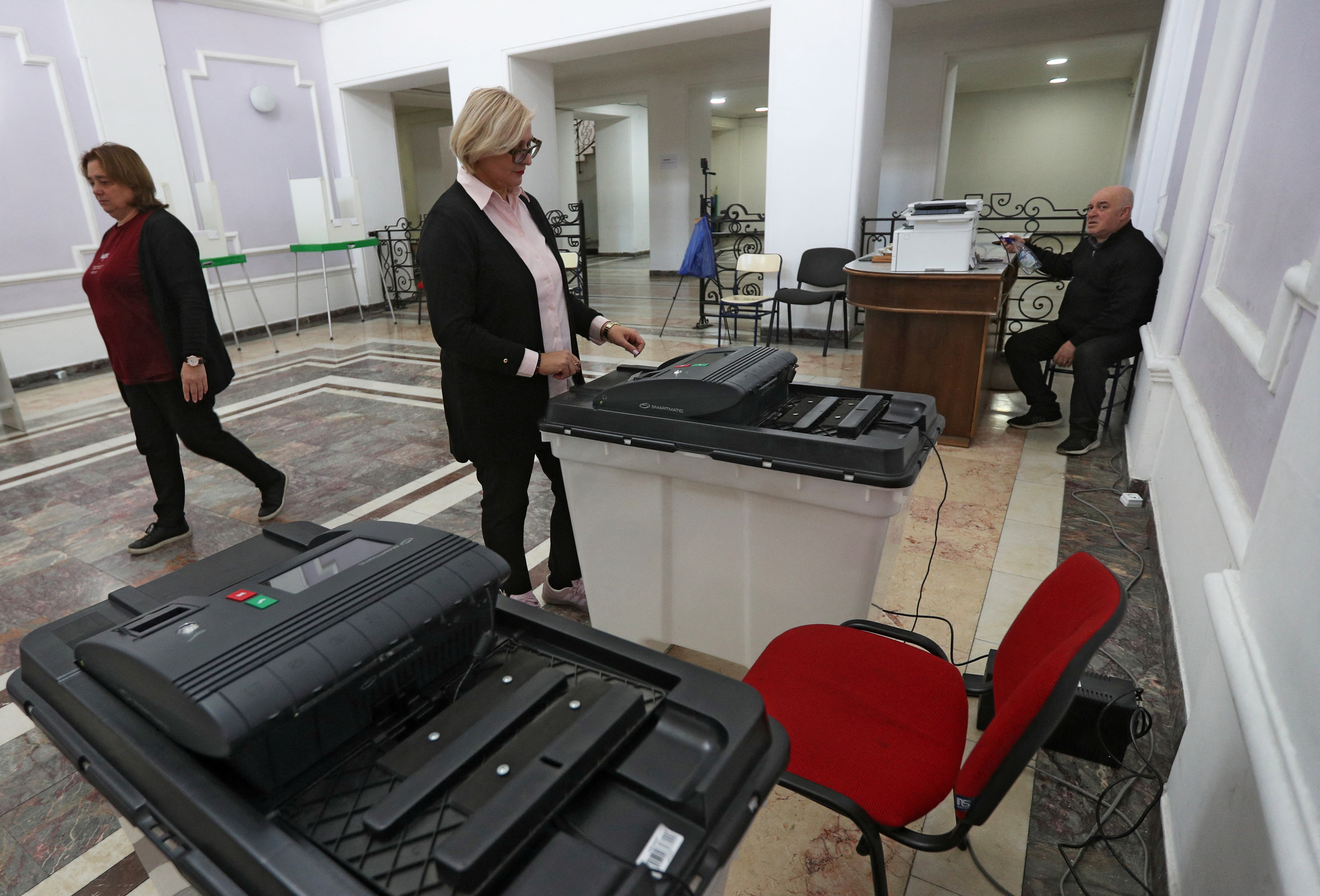 A member of an electoral commission checks a ballot box at a polling station in Tbilisi