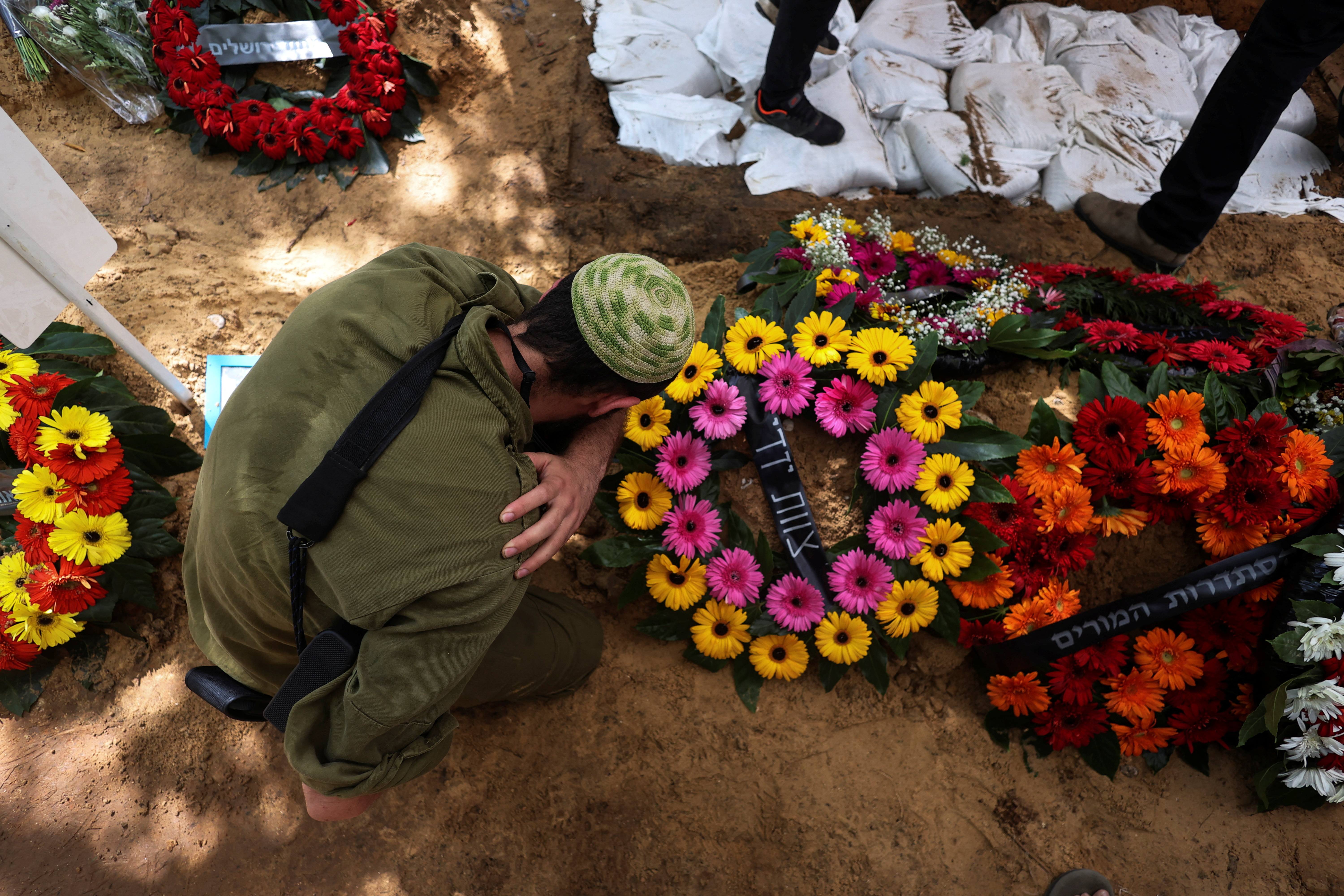 People mourn at the graveside of Amichai Vanino, a soldier who was killed following an attack by Hamas gunmen from Gaza, at his funeral at Mount Herzl Military Cemetery in Jerusalem