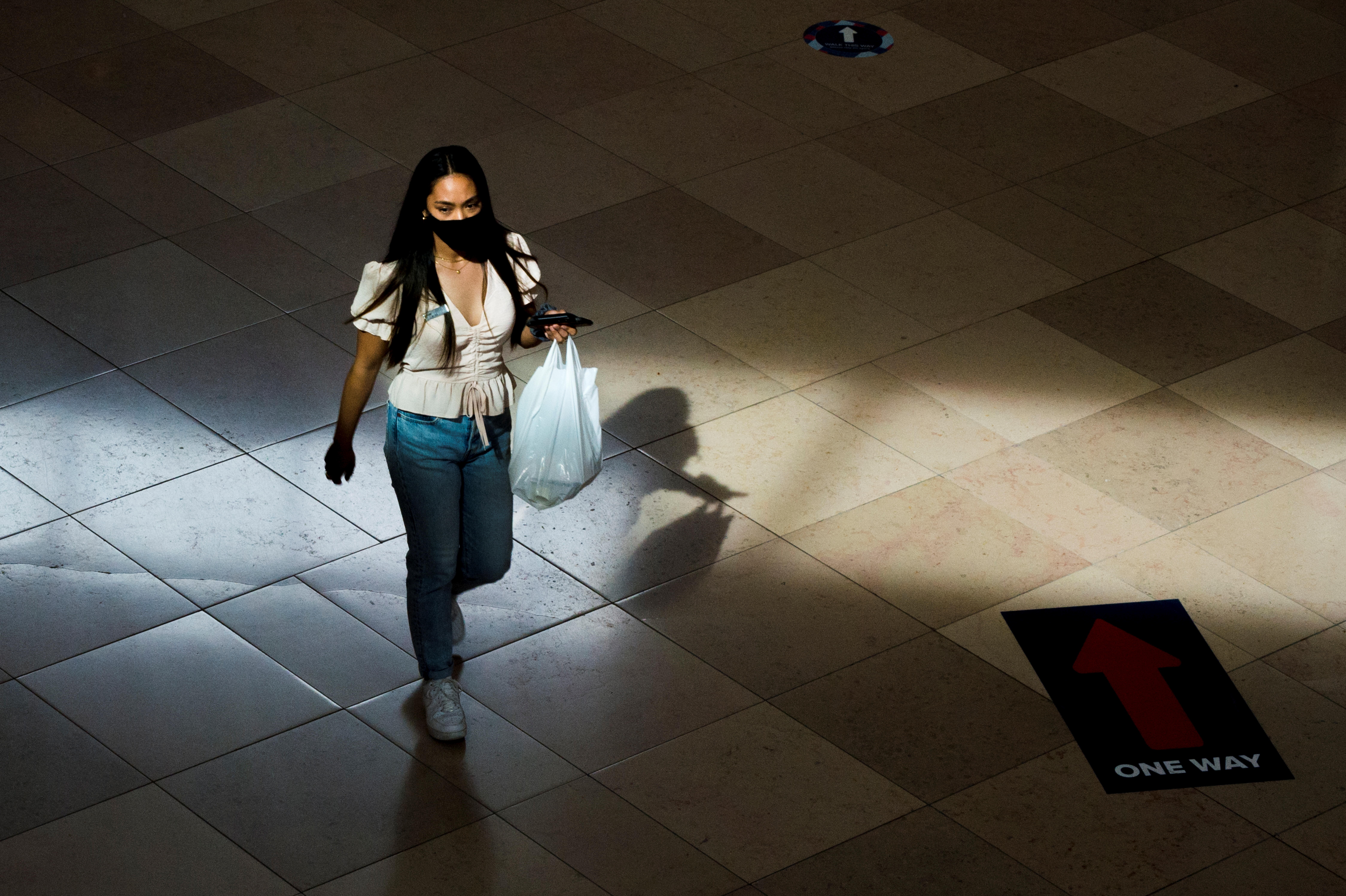 A shopper is illuminated by a beam of light as she walks down a hallway in Sherway Gardens Mall during the stage two reopening from coronavirus disease (COVID-19) restrictions in Toronto, Ontario, Canada June 30, 2021. REUTERS/Alex Filipe