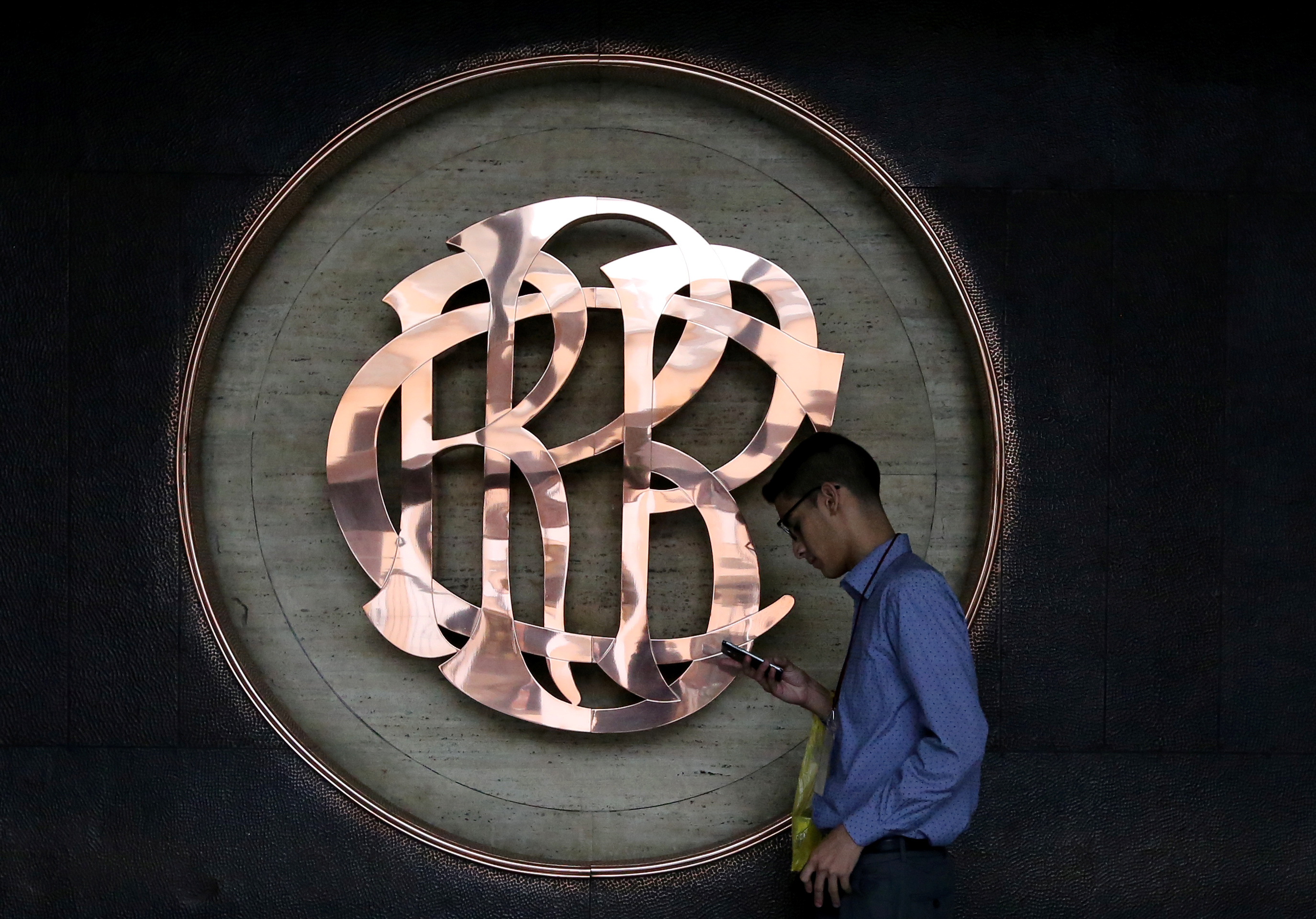 A worker walks pasts the logo of the Central Reserve Bank of Peru (BCRP) inside its headquarters building in Lima