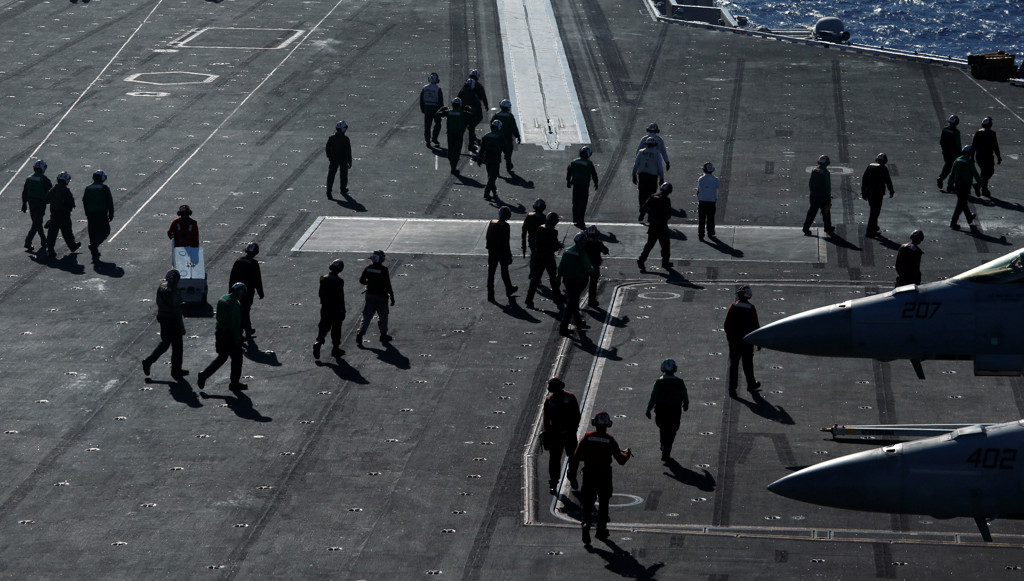 Crew members work on the deck of USS Ronald Reagan in the South China Sea