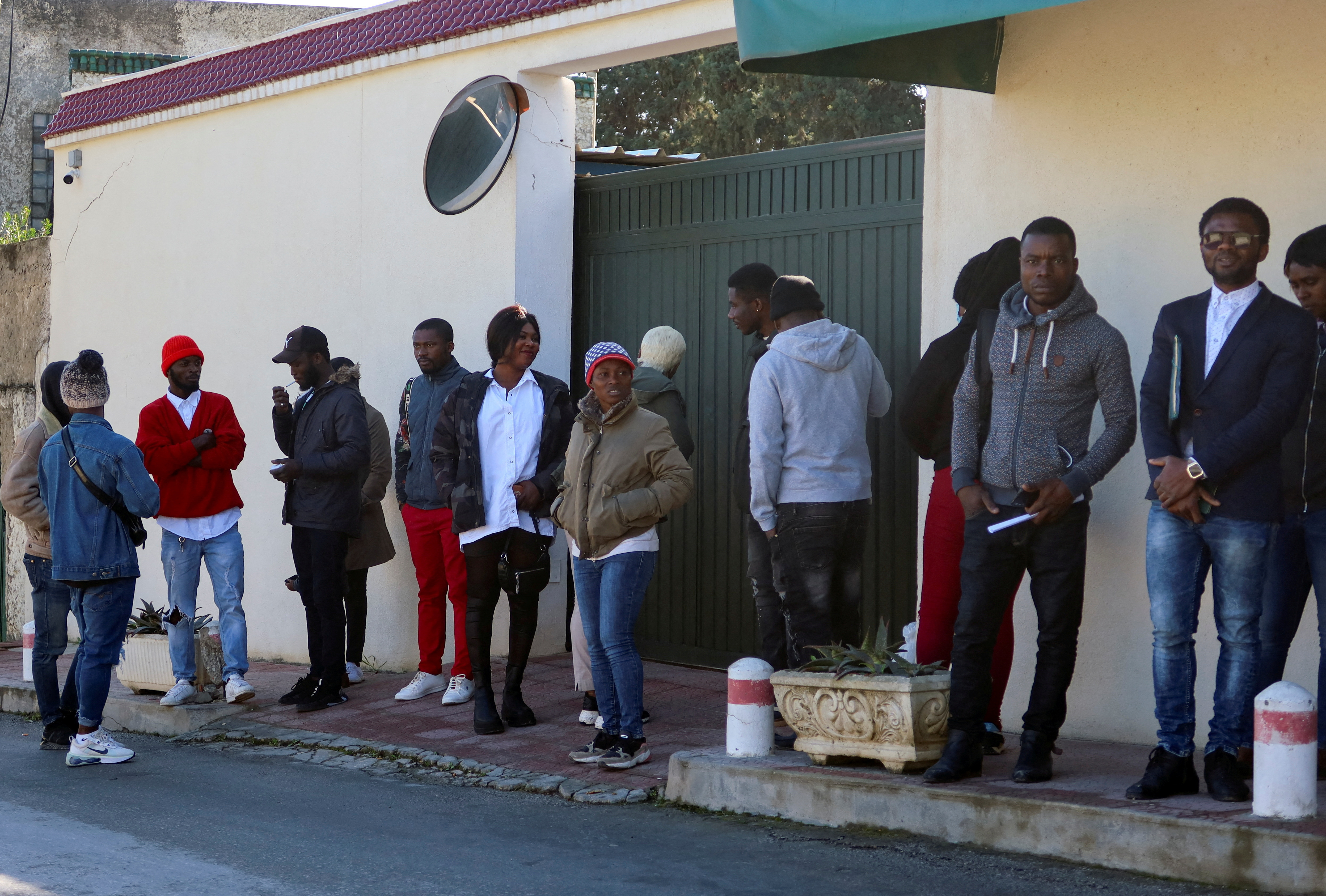 Ivory Coast nationals living in Tunisia wait outside the embassy of Ivory Coast in Tunis