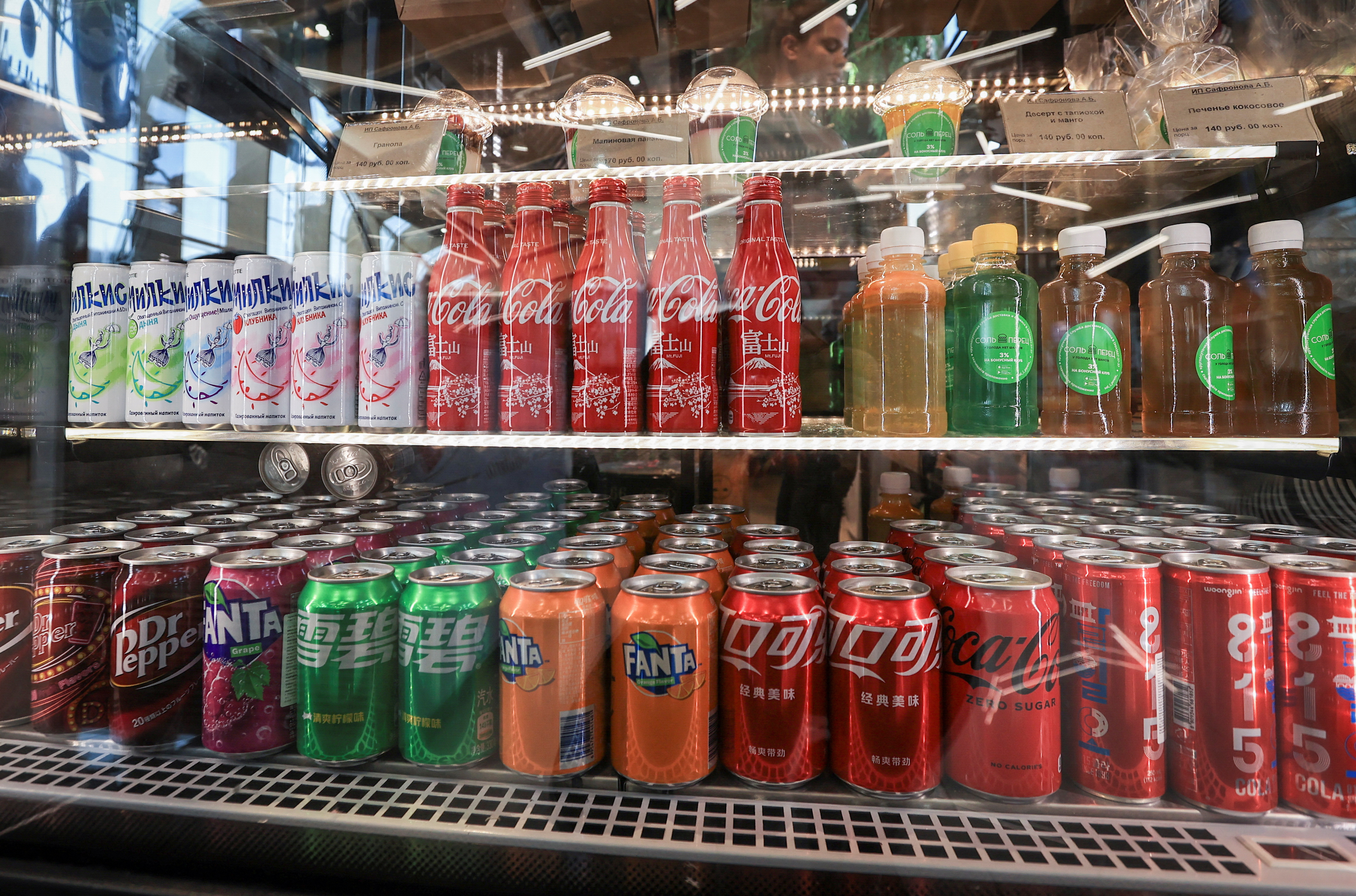 Botellas y latas de Coca Cola importadas de Japón y China junto con otros envases de refrescos se exhiben para la venta en Vladivostok