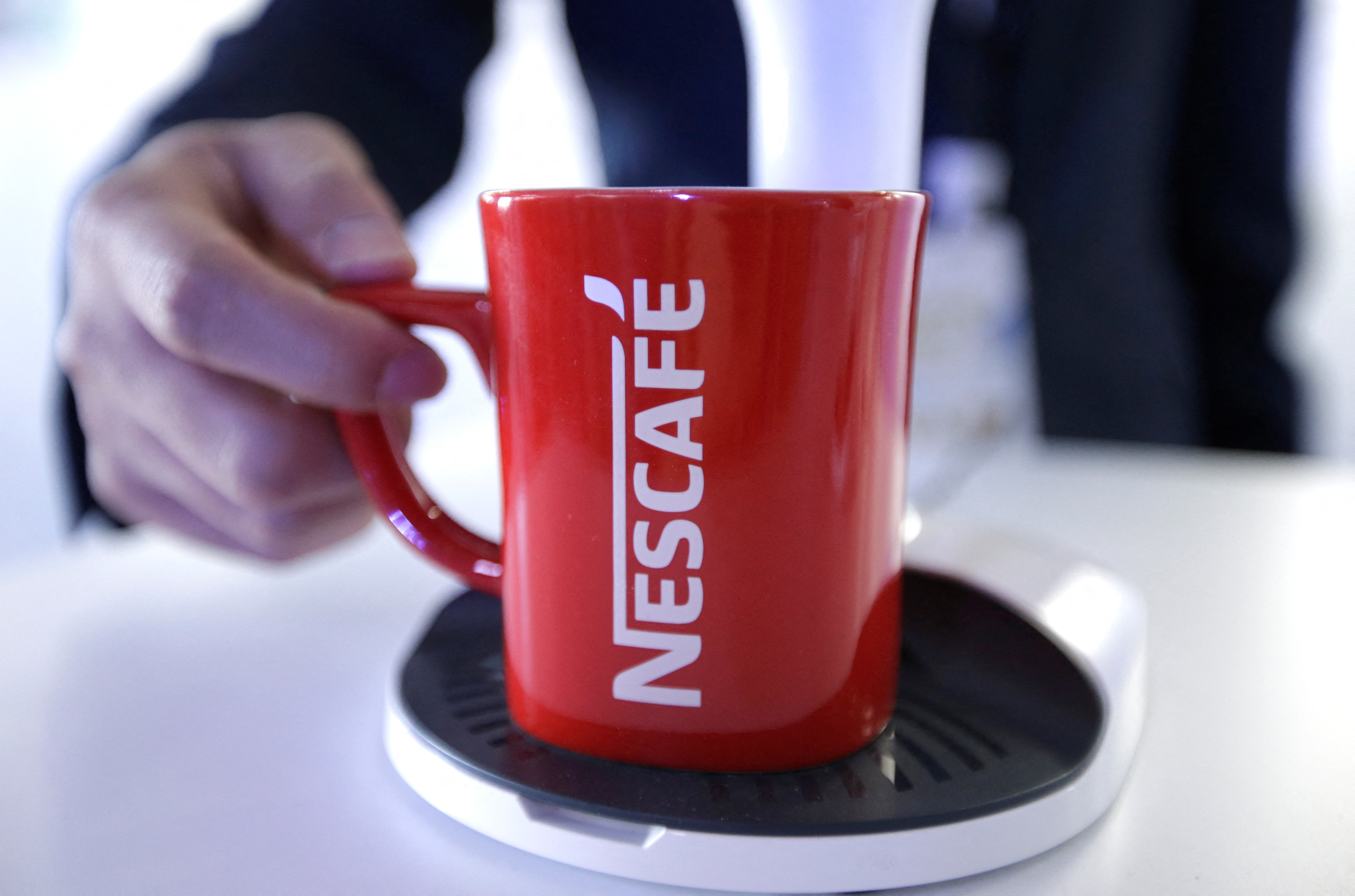 An employee holds a Nescafe cup at Nestle R&D Center in Beijing