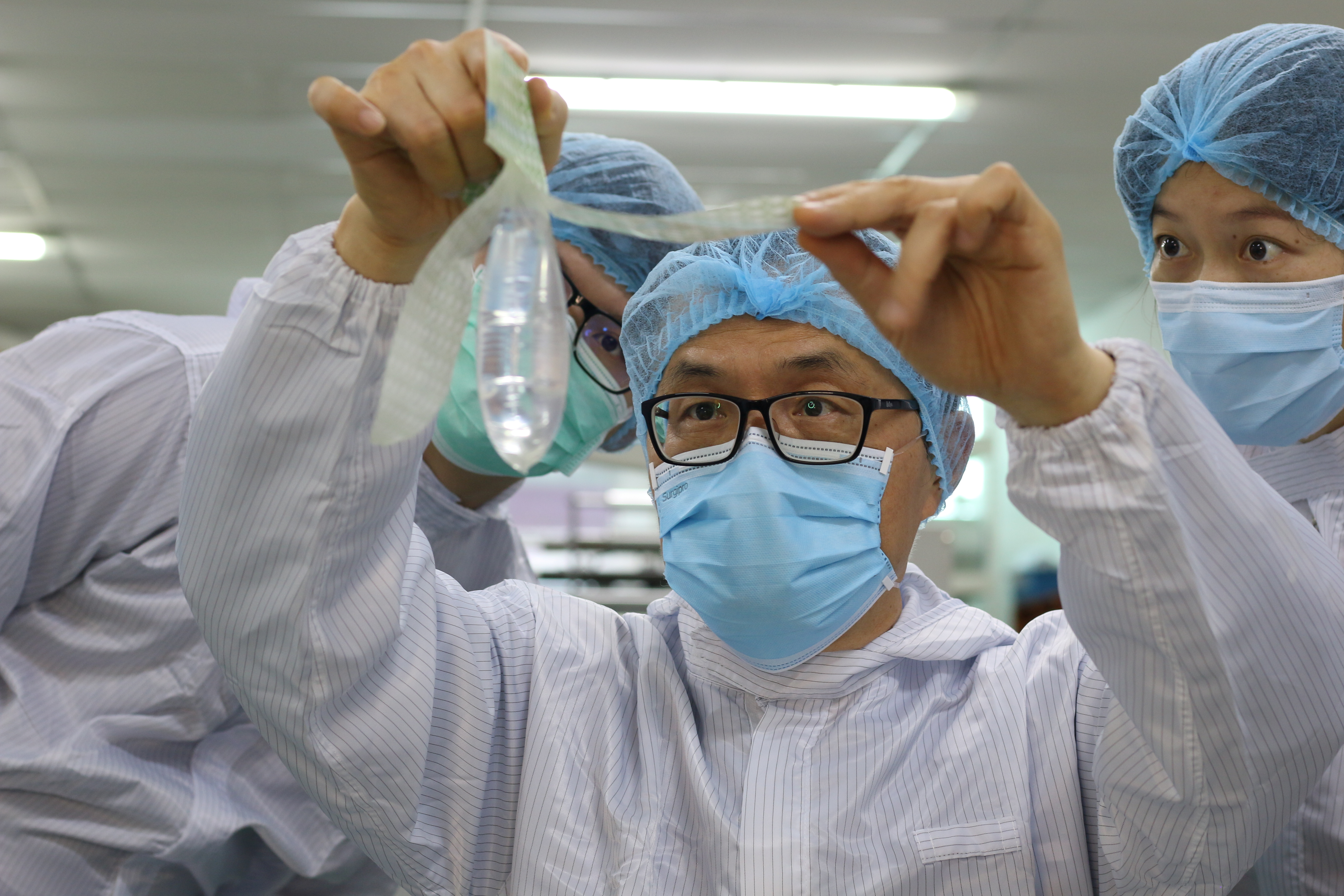 John Tang Ing Ching, founder and inventor of Wondaleaf Unisex Condom inspects the unisex condom at his factory in Sibu