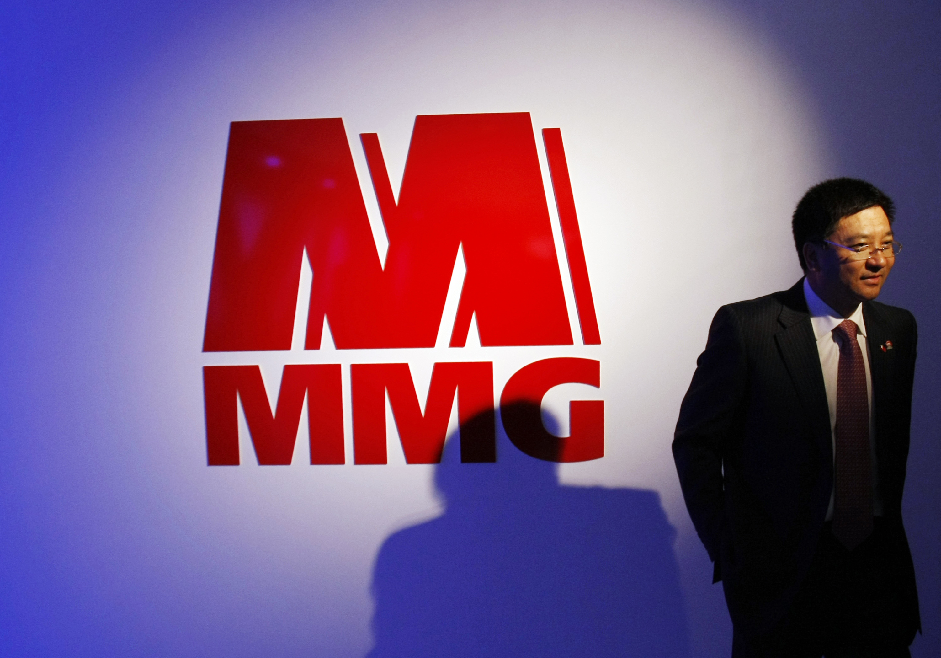 A man walks past the MMG Ltd logo after a news conference in Melbourne