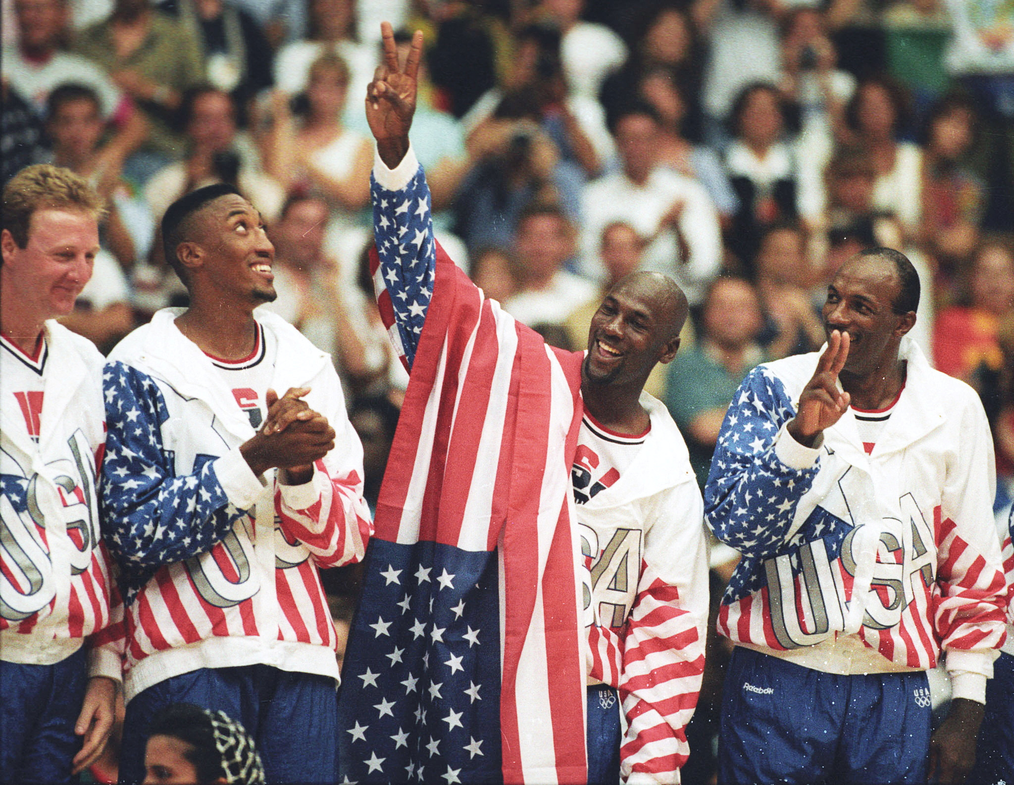 U.S. basketball player Michael Jordan flashes a victory sign as he stands with team mates Larry Bird, Scottie Pippen and Clyde Drexler after winning the Olympic gold in Barcelona