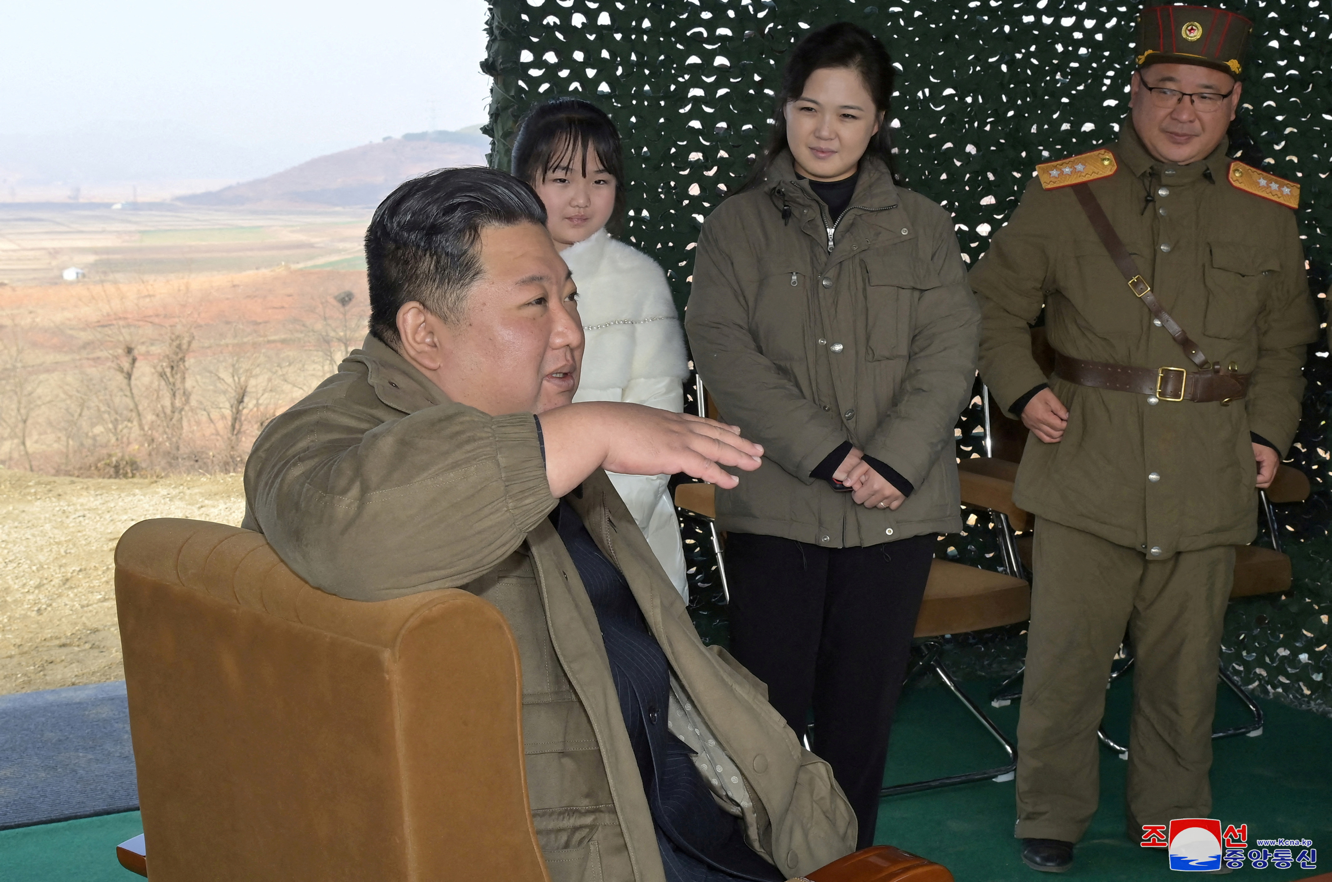 North Korean leader Kim Jong Un, with his wife Ri Sol Ju and their daughter, speaks on the day of the launch of an ICBM in this undated photo released by KCNA