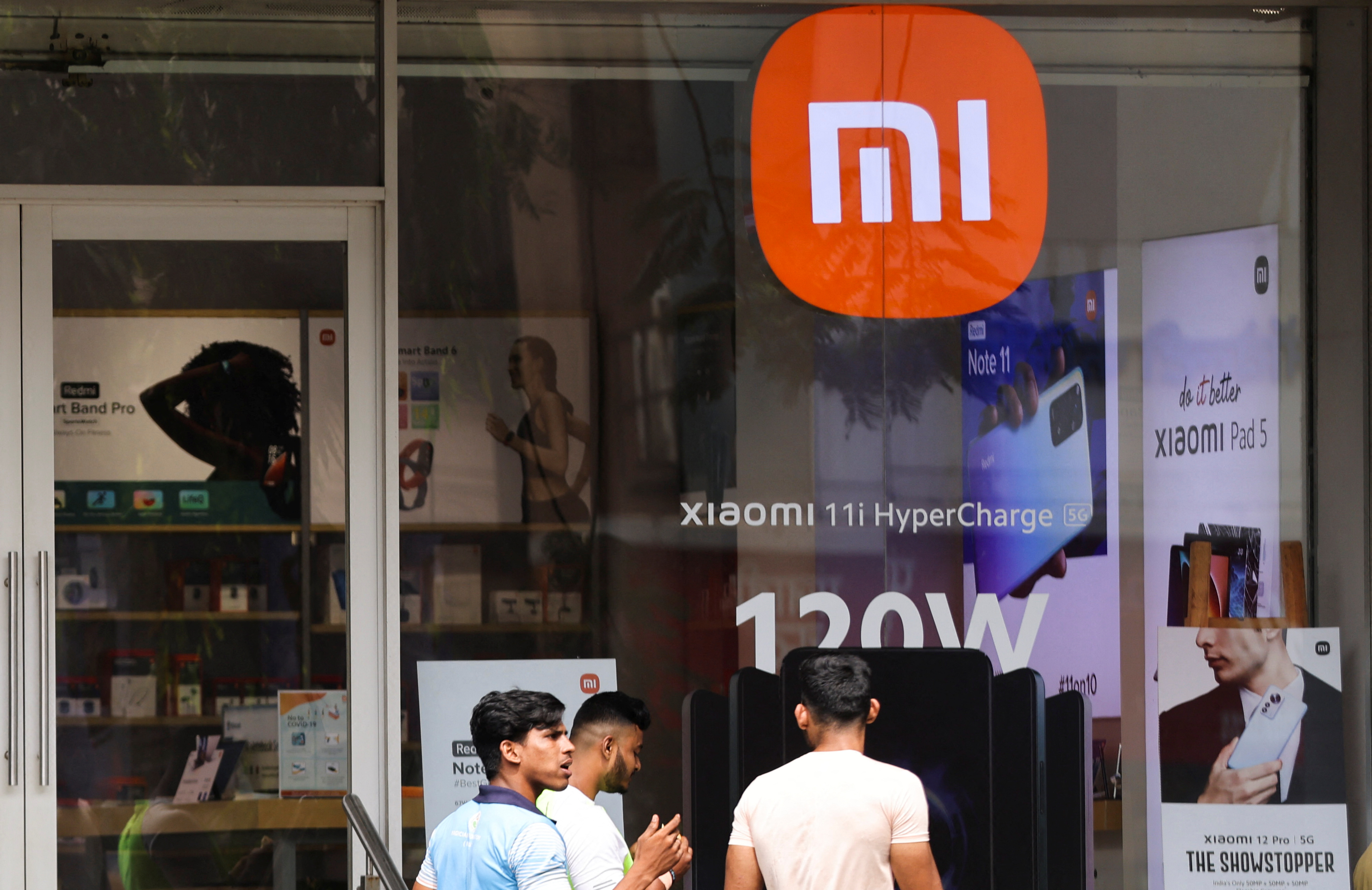 People walk in front of a Xiaomi store, the Chinese manufacturer of consumer electronics, in Mumbai