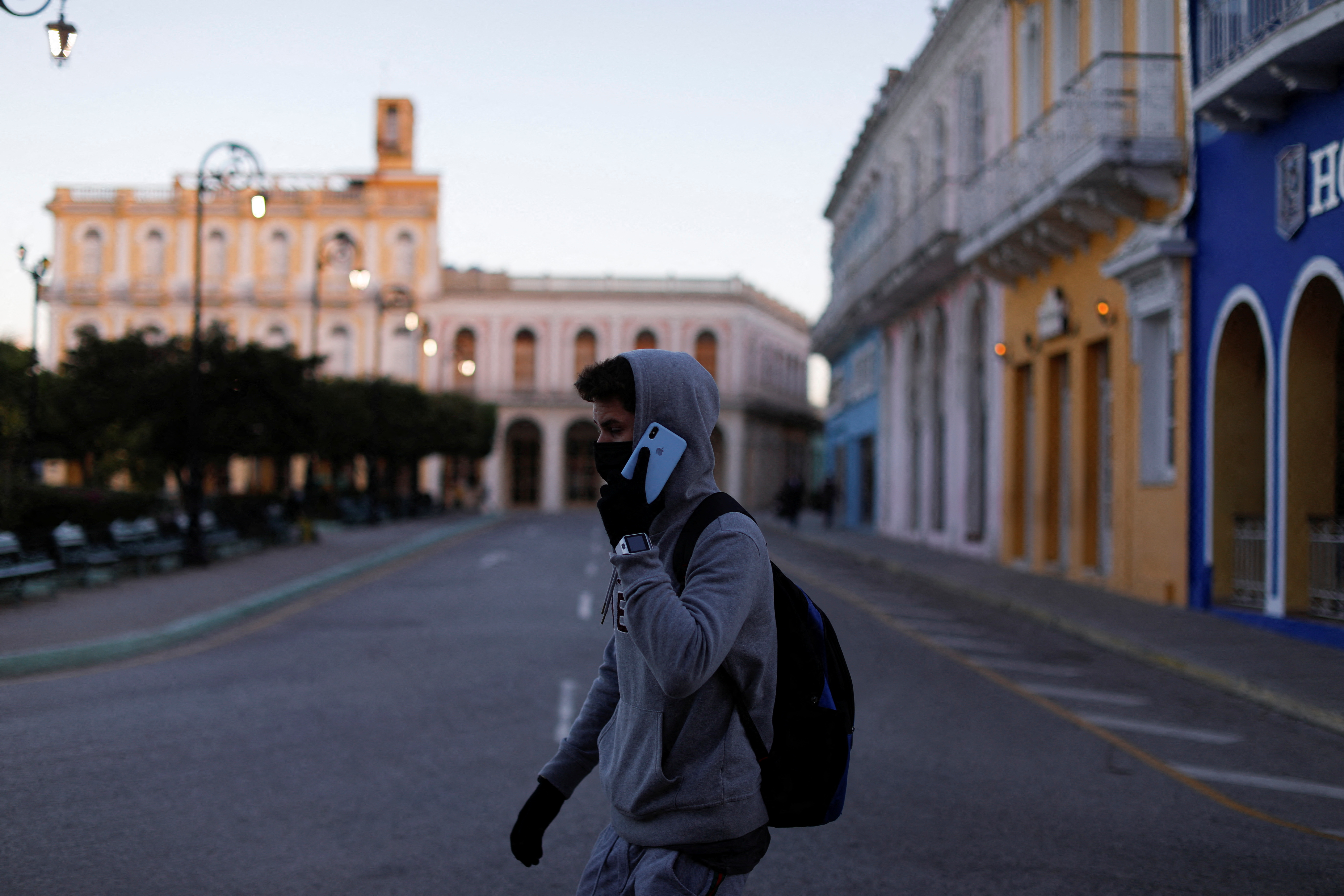 A man wearing gloves and cold clothing speaks on the phone as he walks in Sancti Spiritus, Cuba, January 31, 2022. REUTERS/Amanda Perobelli