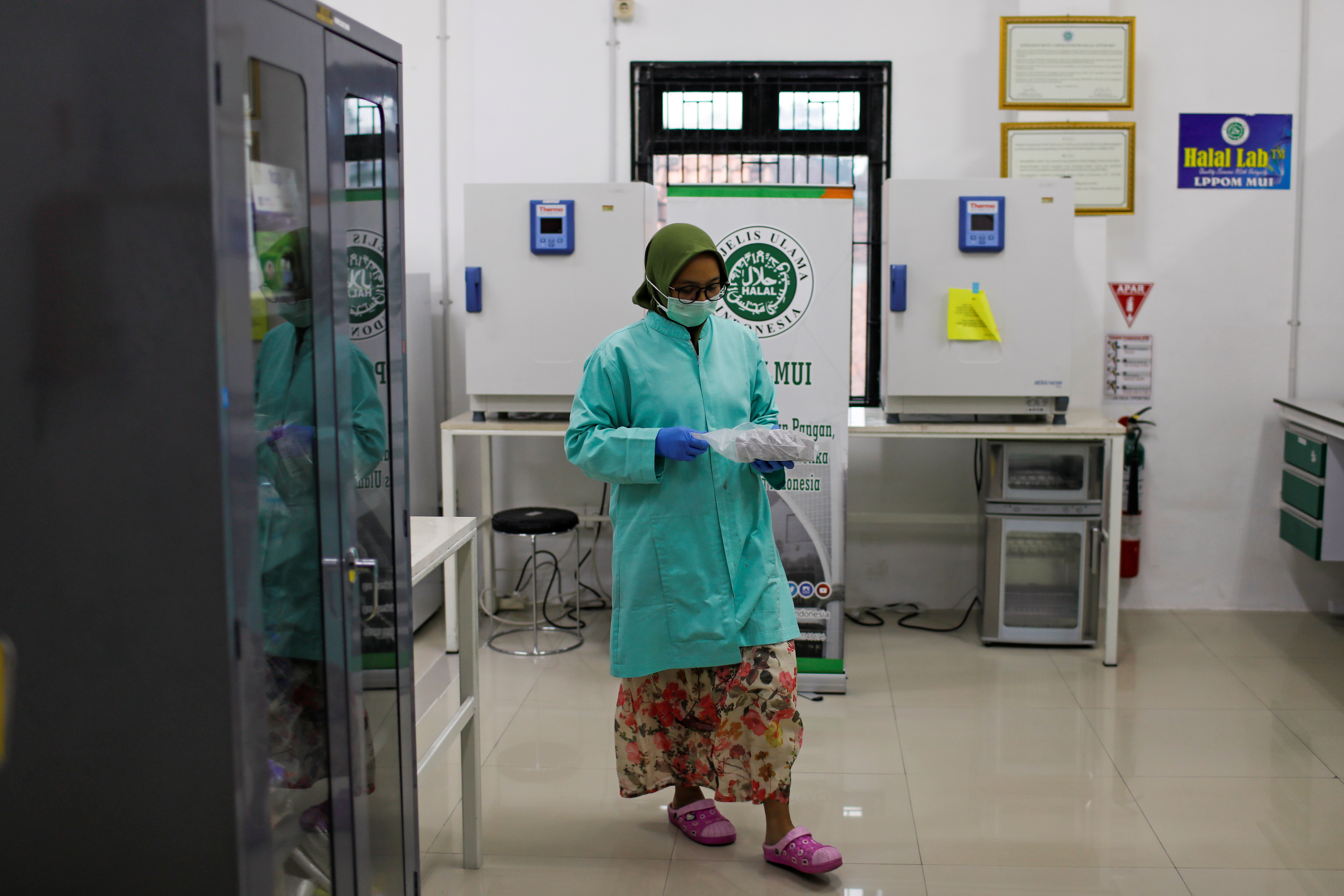 Analyst of Global Halal Centre walks inside a laboratorium, in Bogor