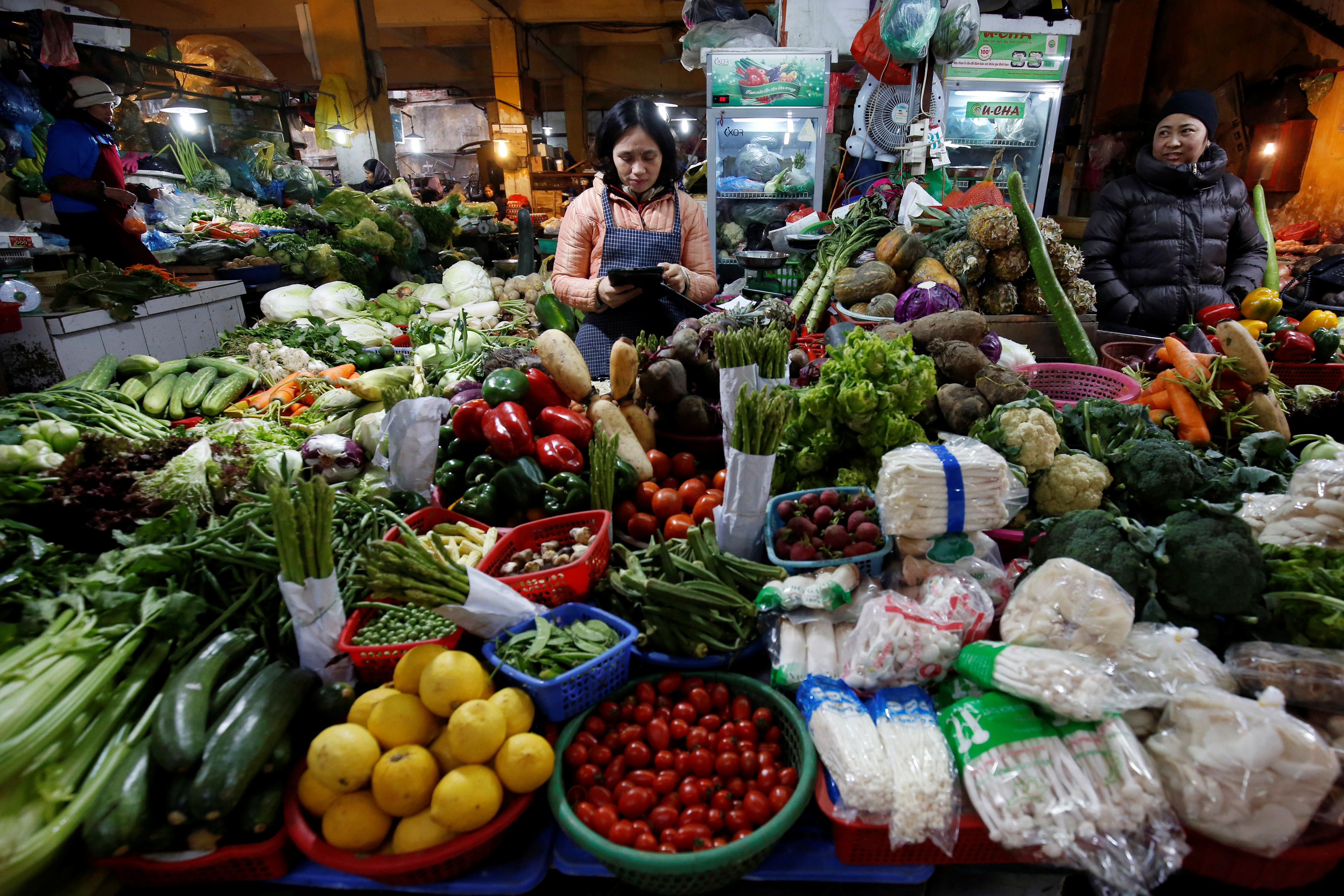 Women sell vegetables at a market in Hanoi