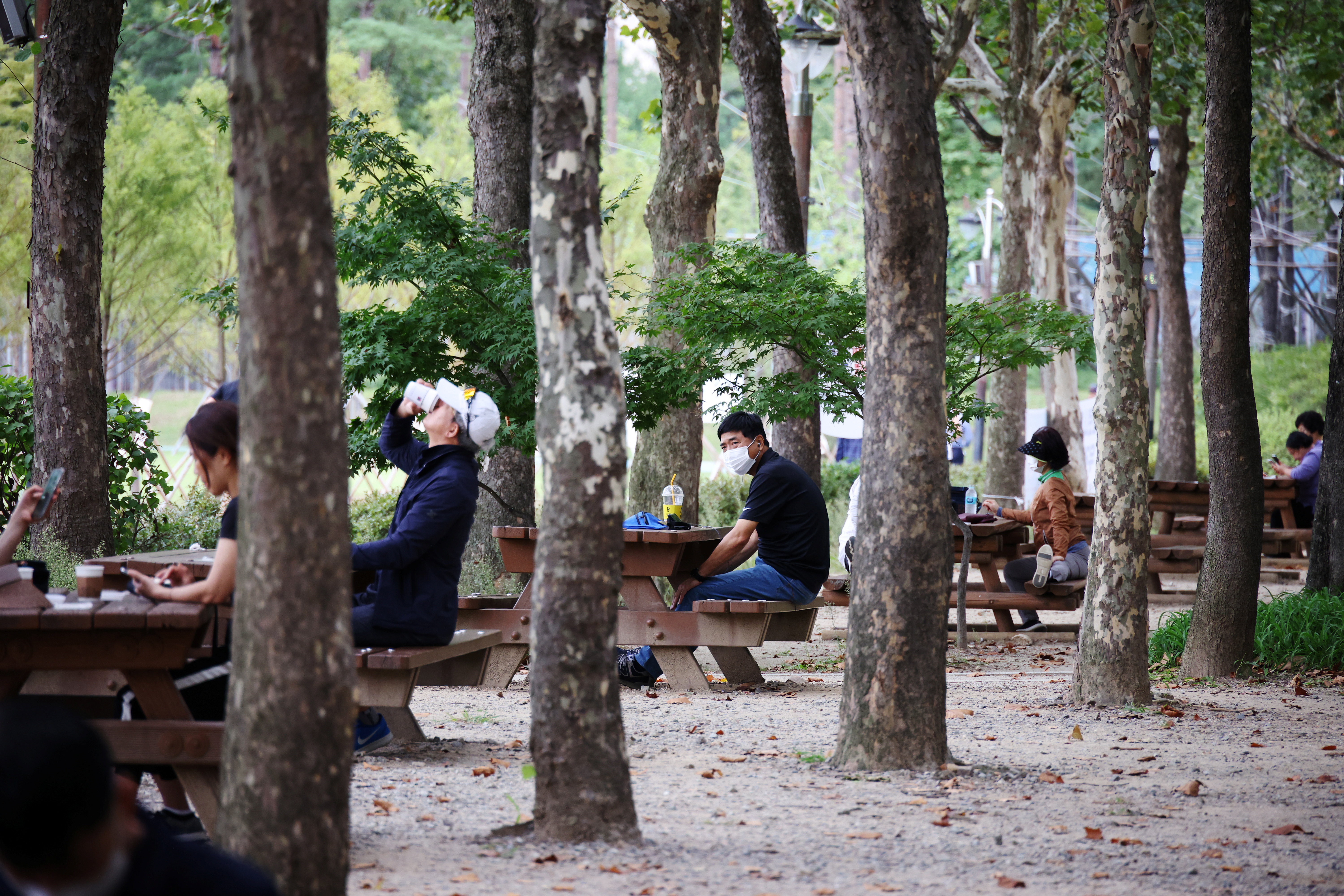 People rest as they keep social distancing to avoid the spread of the coronavirus disease (COVID-19) at a park in Seoul
