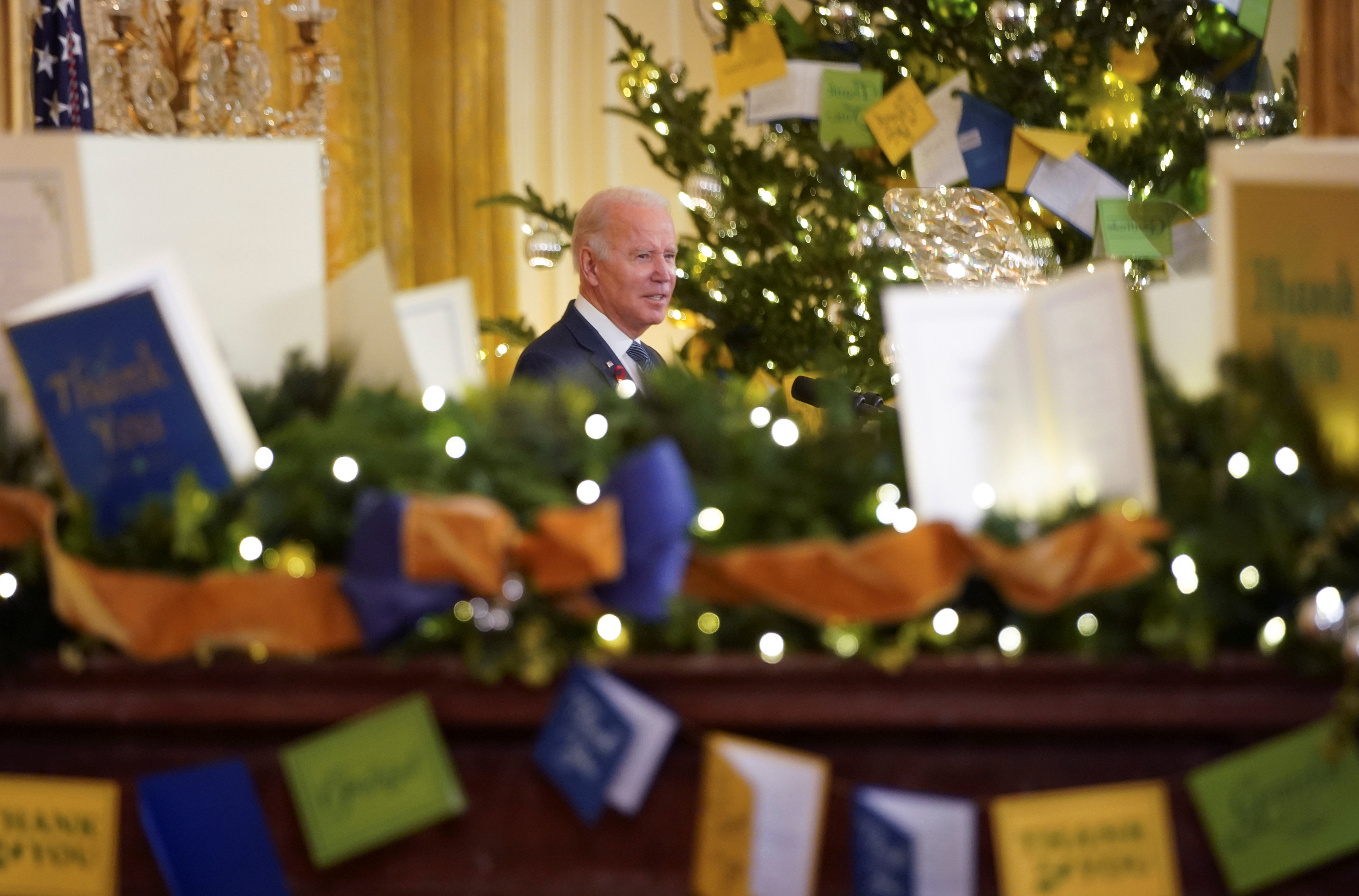 Reflected in a mirror decorated for Christmas, U.S. President Joe Biden delivers remarks to commemorate World AIDS Day at the White House in Washington, U.S., December 1, 2021. REUTERS/Kevin Lamarque     