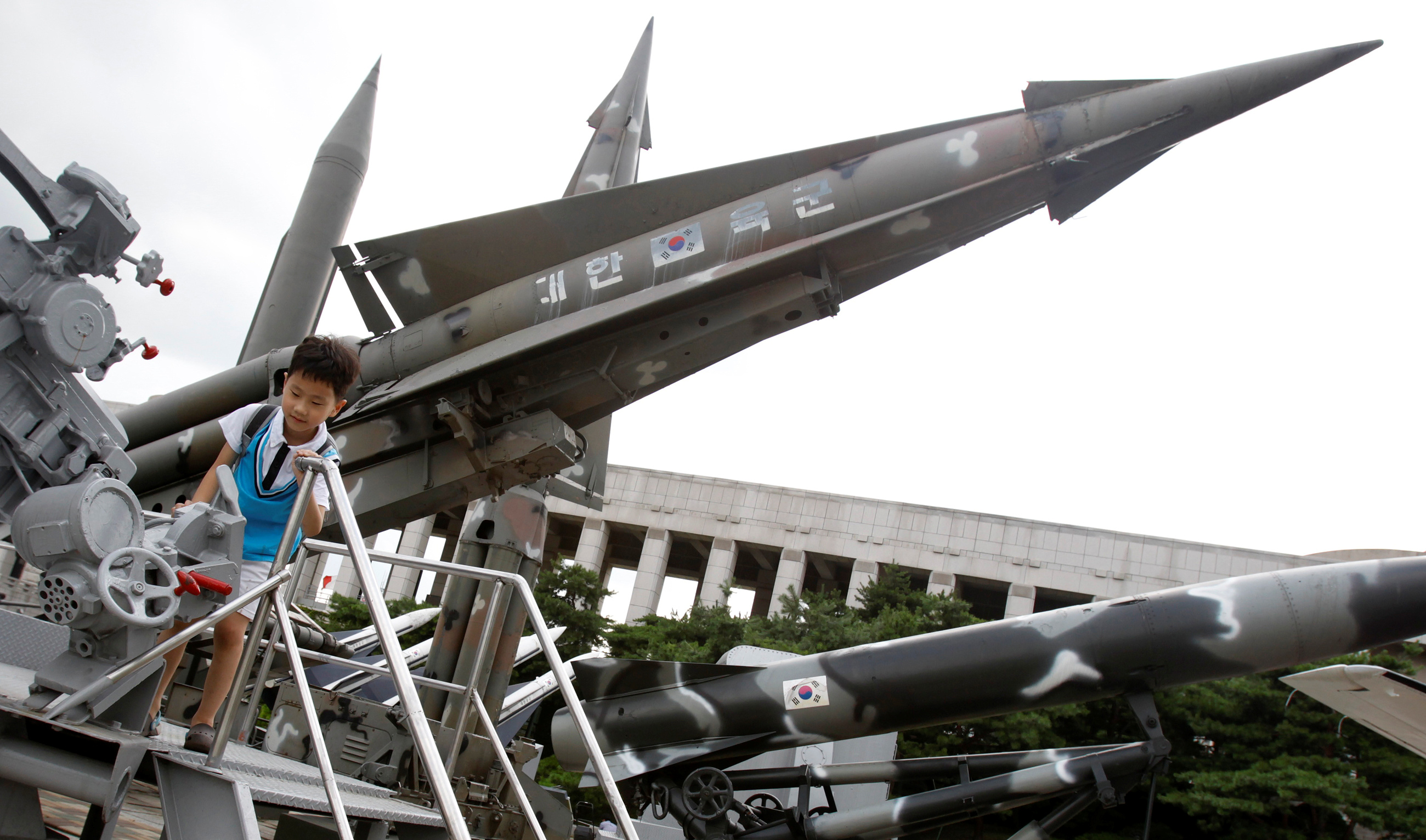 A child plays with old weapons displayed for visitors at the Korean War Memorial Museum in Seoul