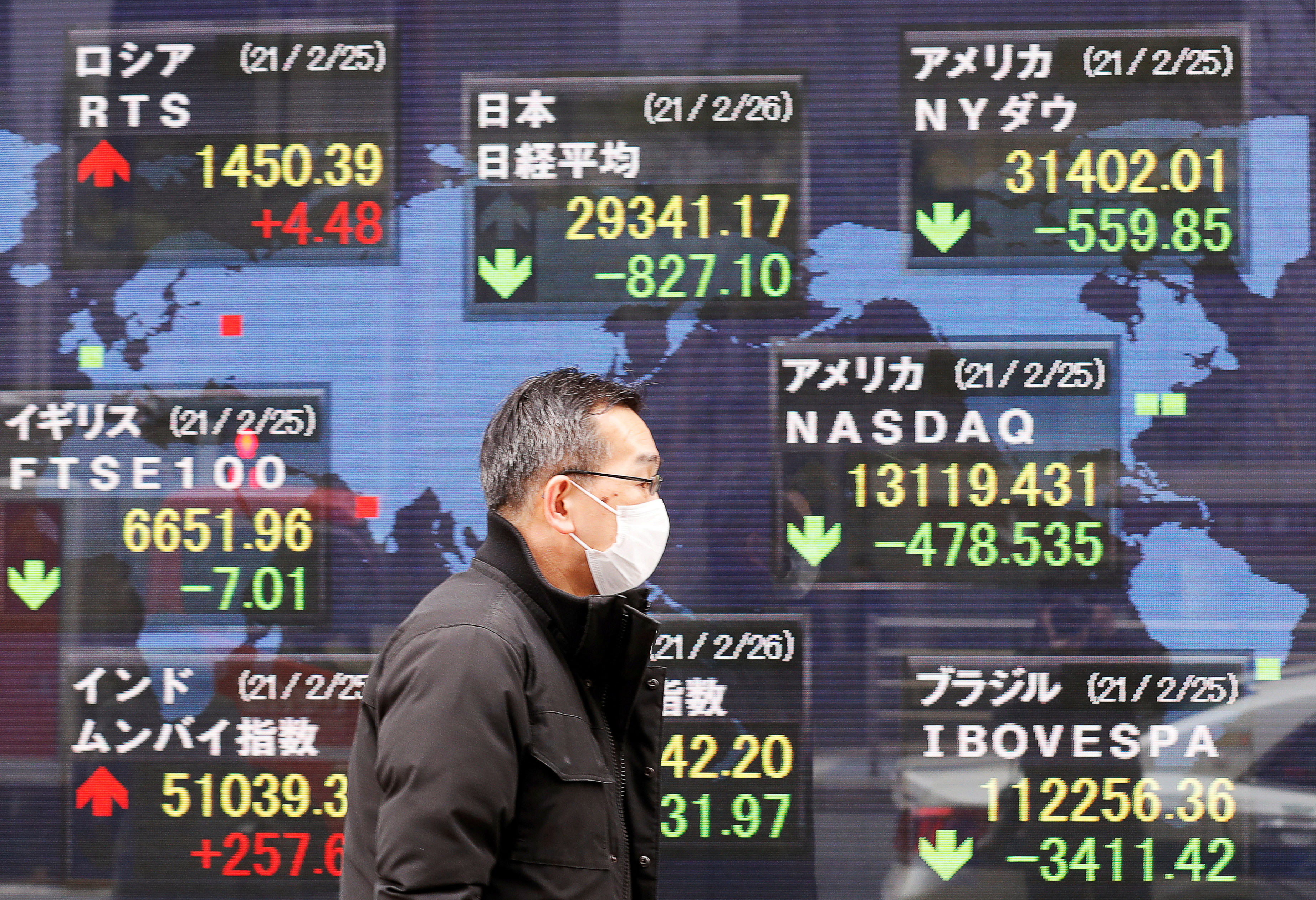 A man walks past a stock quotation board at a brokerage in Tokyo