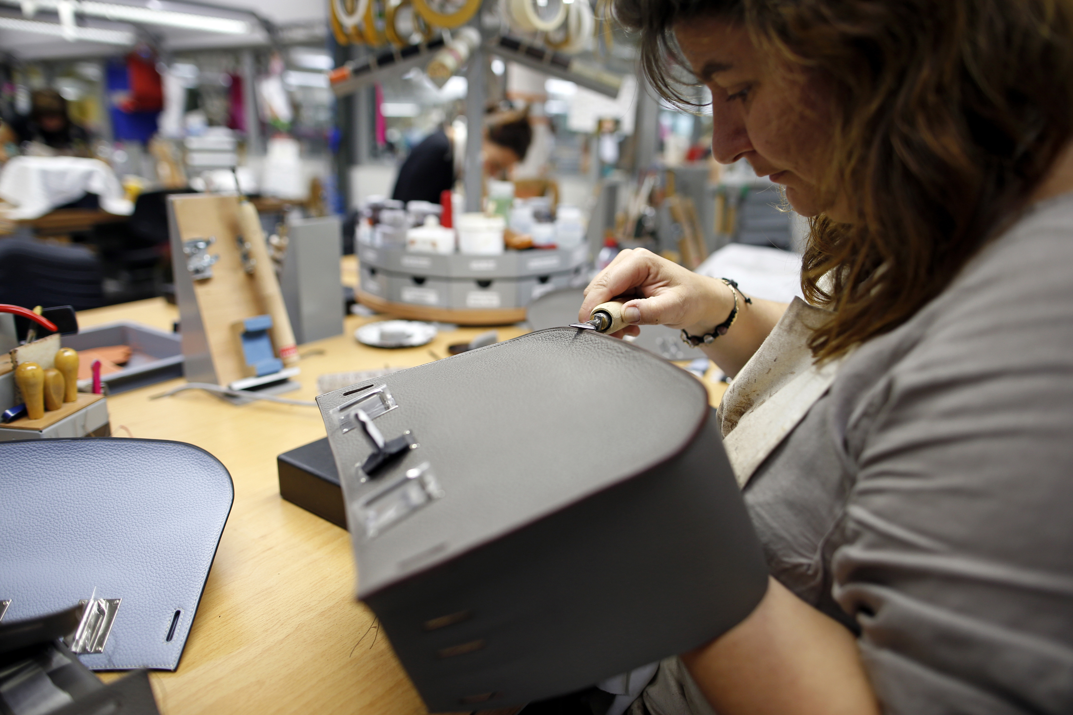 A craftswoman works on a Birkin bag at the luxury goods Hermes factory in Seloncourt