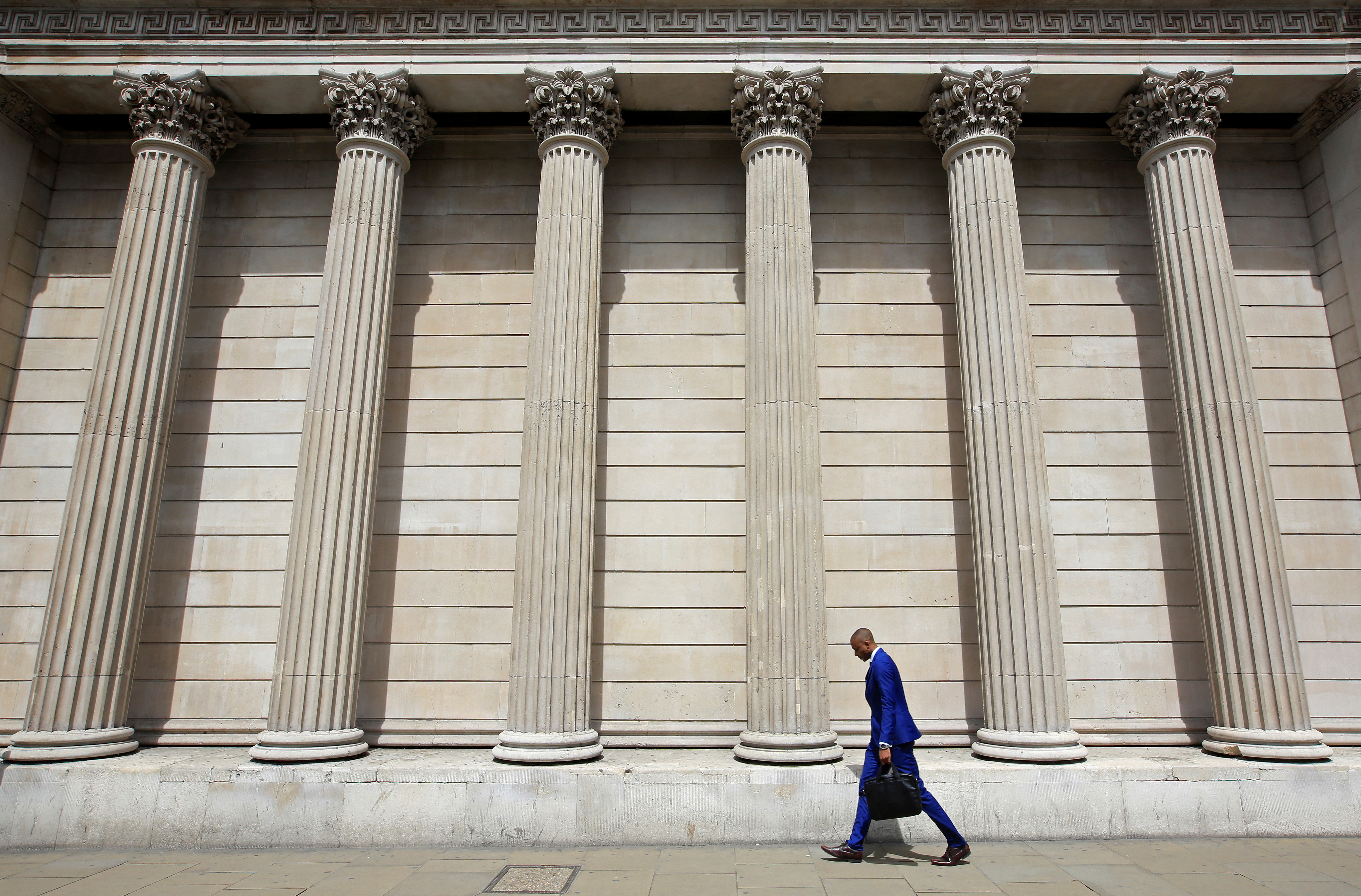 A man walks past the Bank of England in the City of London