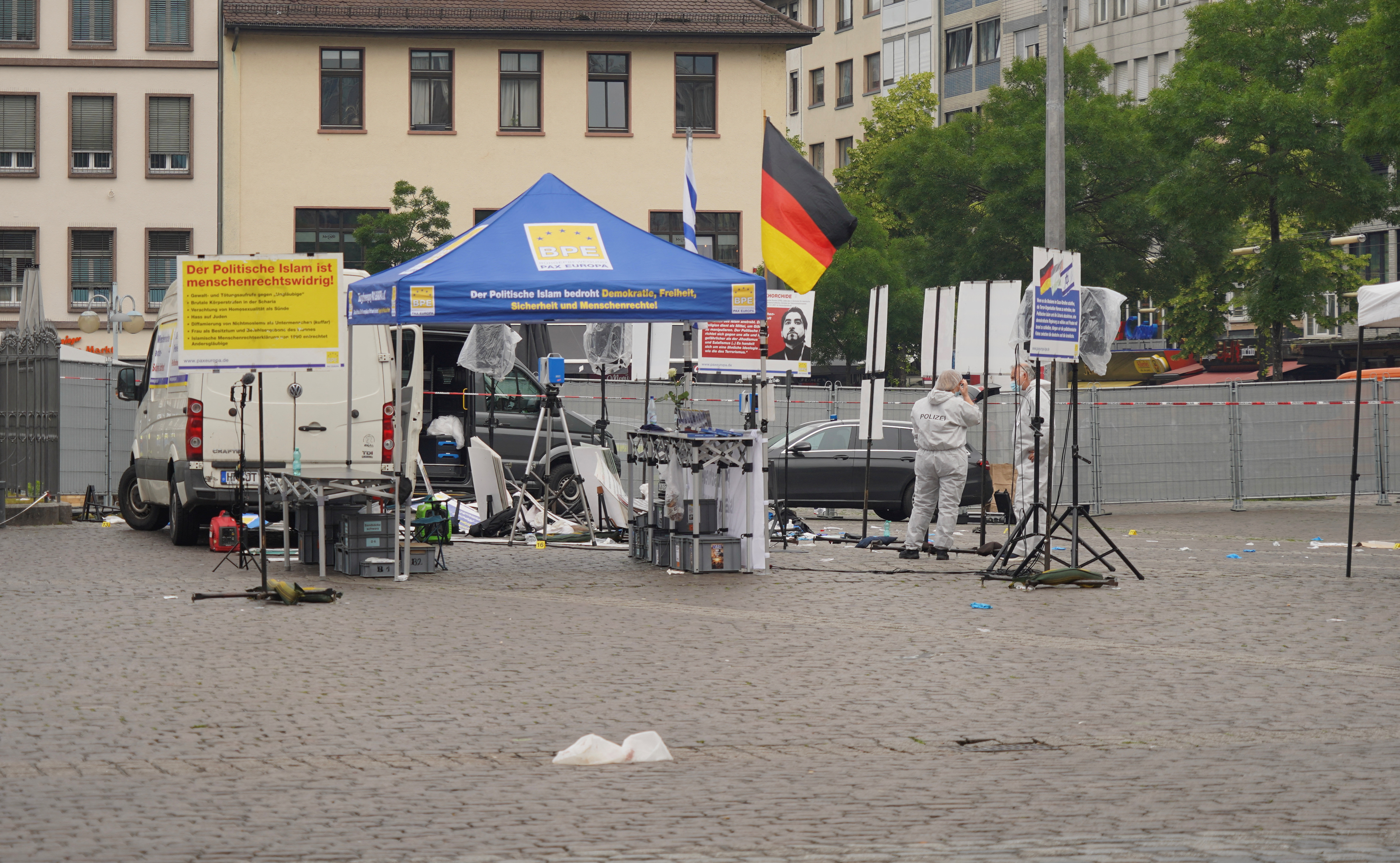 Police investigators work at the scene where a man attacked people in the central market of the city of Mannheim