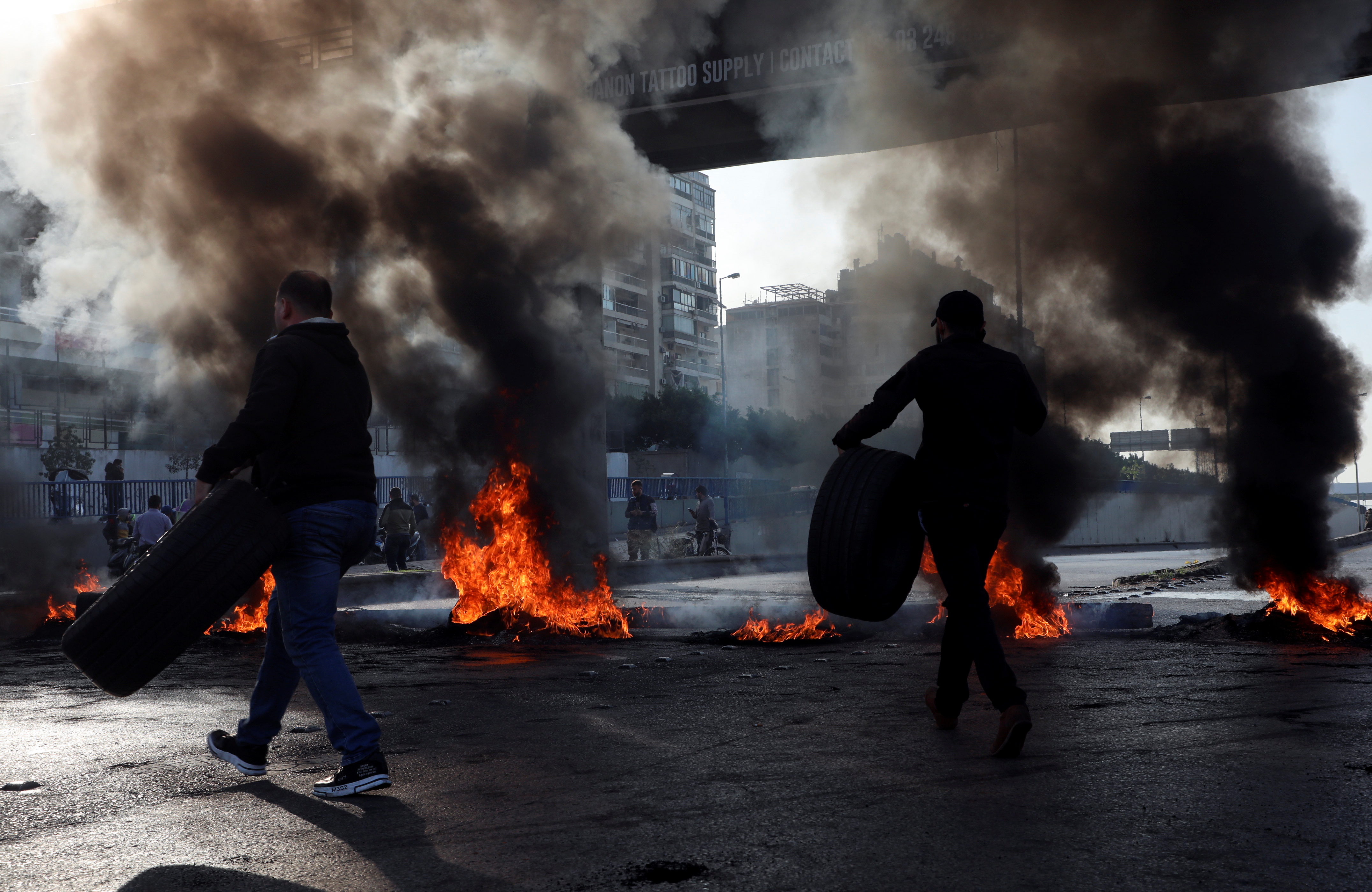 Demonstrators block a road with burning tires during a protest in Beirut