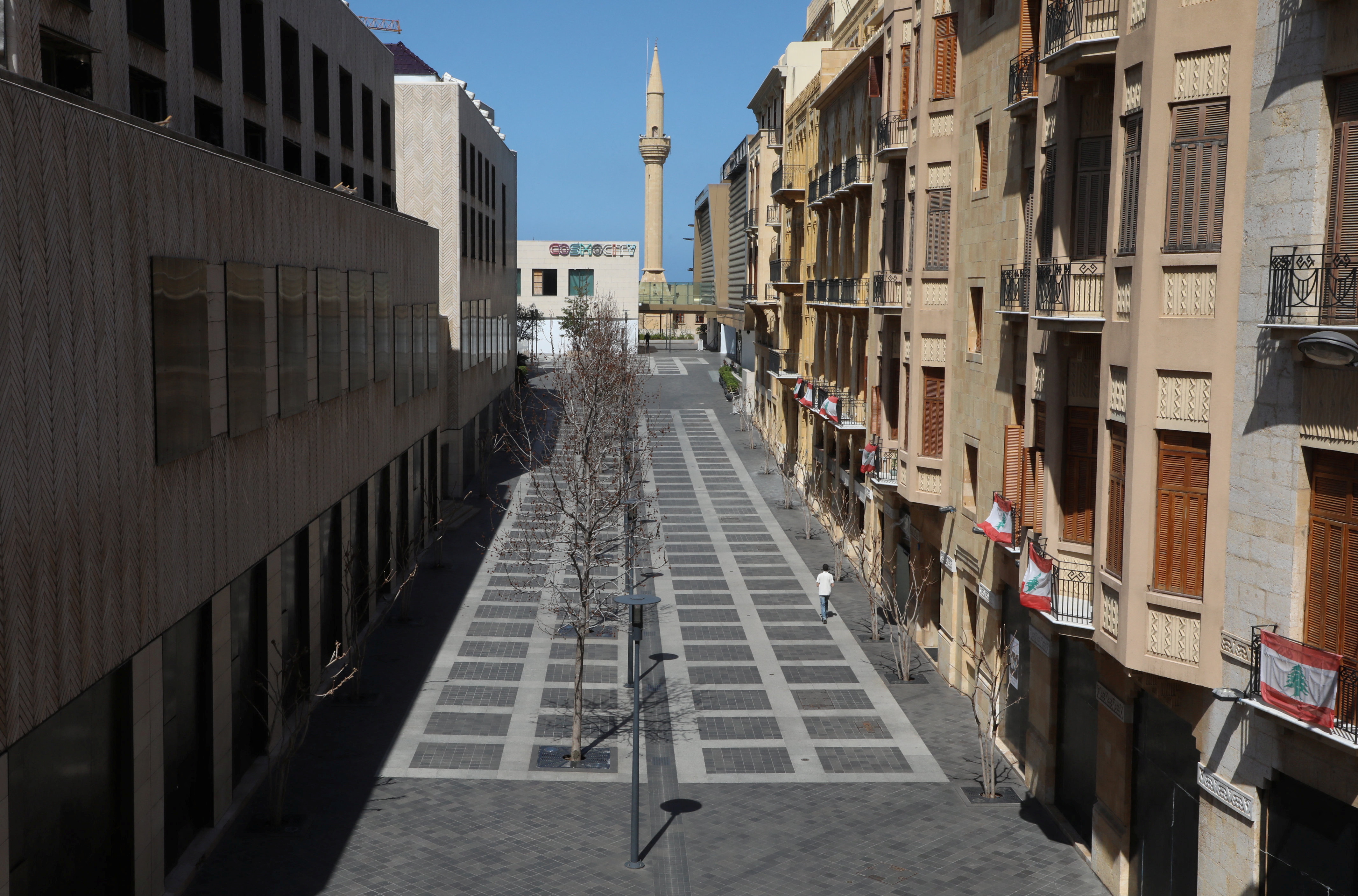 A man walks along an empty shopping district in Beirut