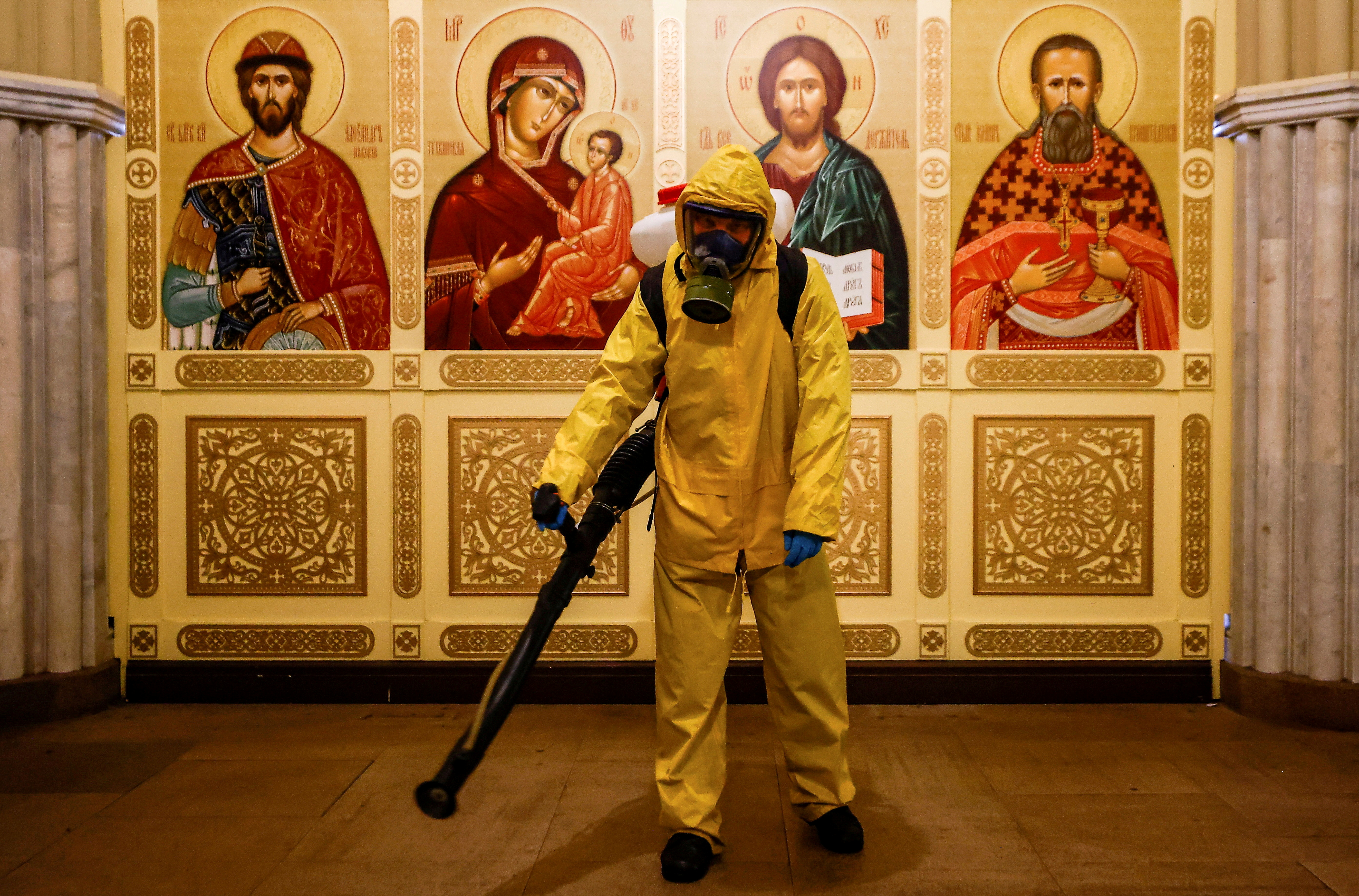A specialist wearing personal protective equipment (PPE) sprays disinfectant while sanitizing a chapel inside the building of the Leningradsky railway station amid the outbreak of the coronavirus disease (COVID-19) in Moscow, Russia October 19, 2021. REUTERS/Maxim Shemetov