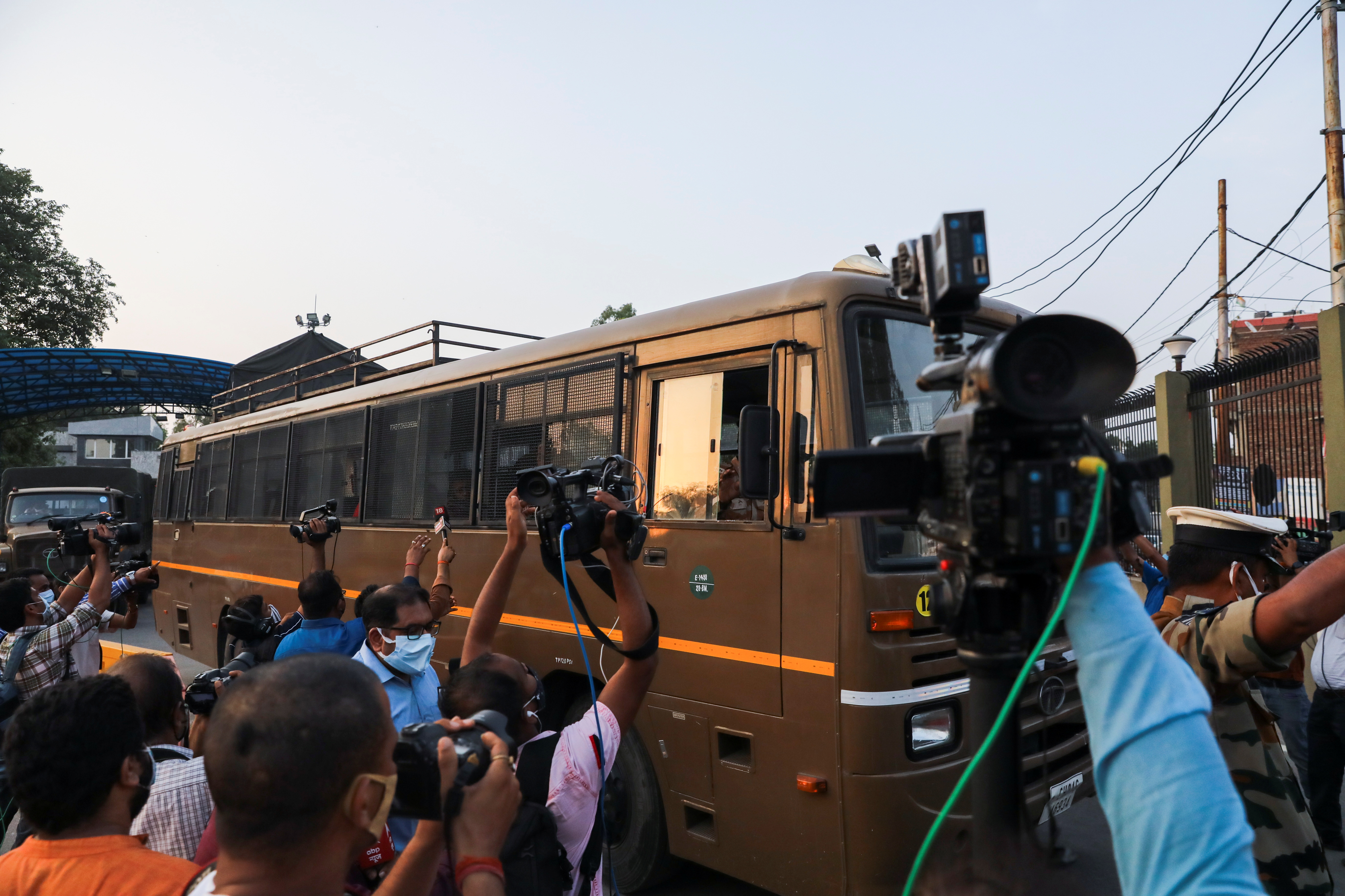 Members of media rush as an Indo-Tibetan Border Police (ITBP) bus carrying people who were evacuated from Kabul leaves the Hindon Air Force Station in Ghaziabad