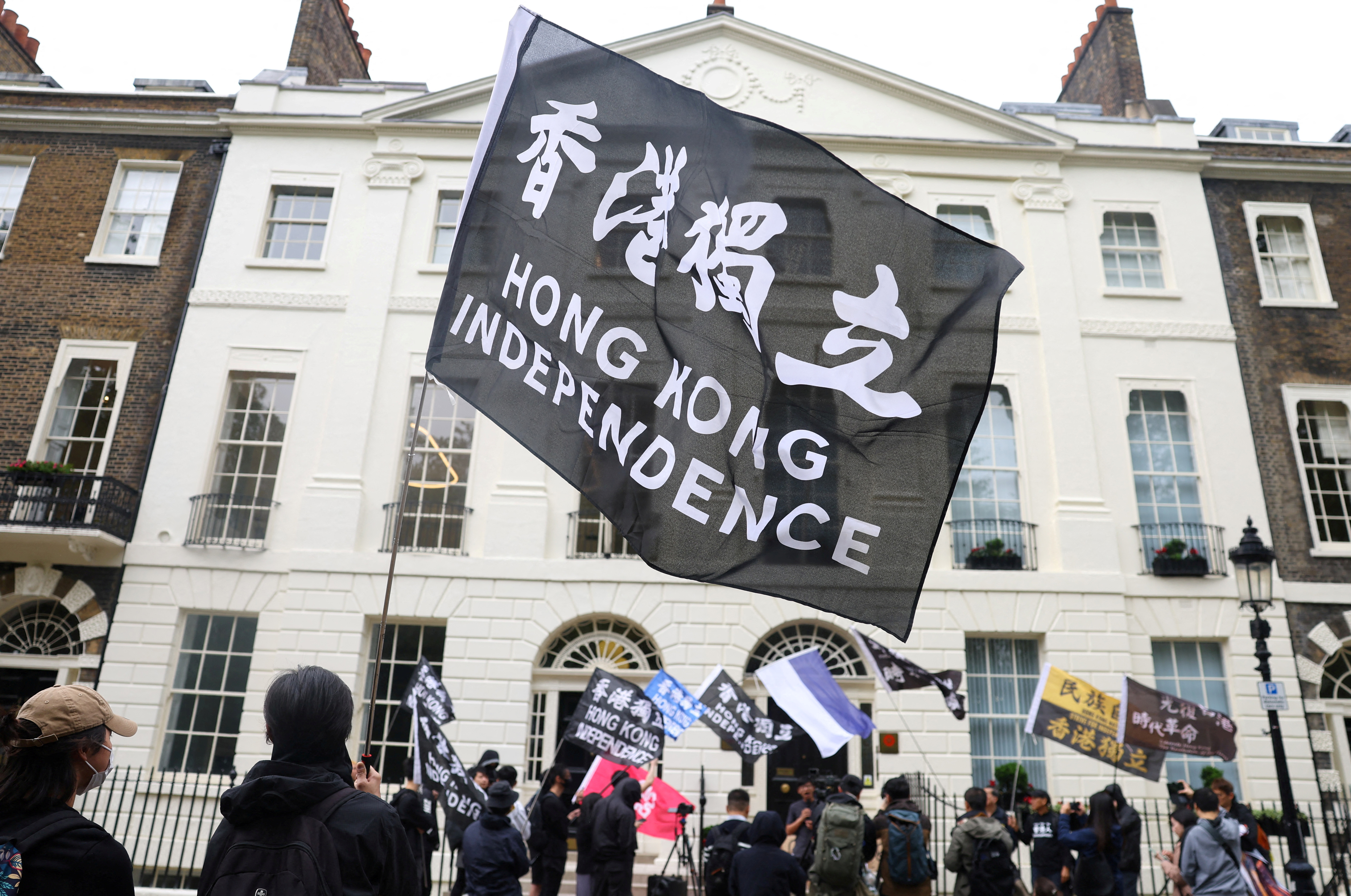 People demonstrate outside the Hong Kong Economic and Trade Office, after three men were charged with assisting Hong Kong's foreign intelligence service in Britain, in London