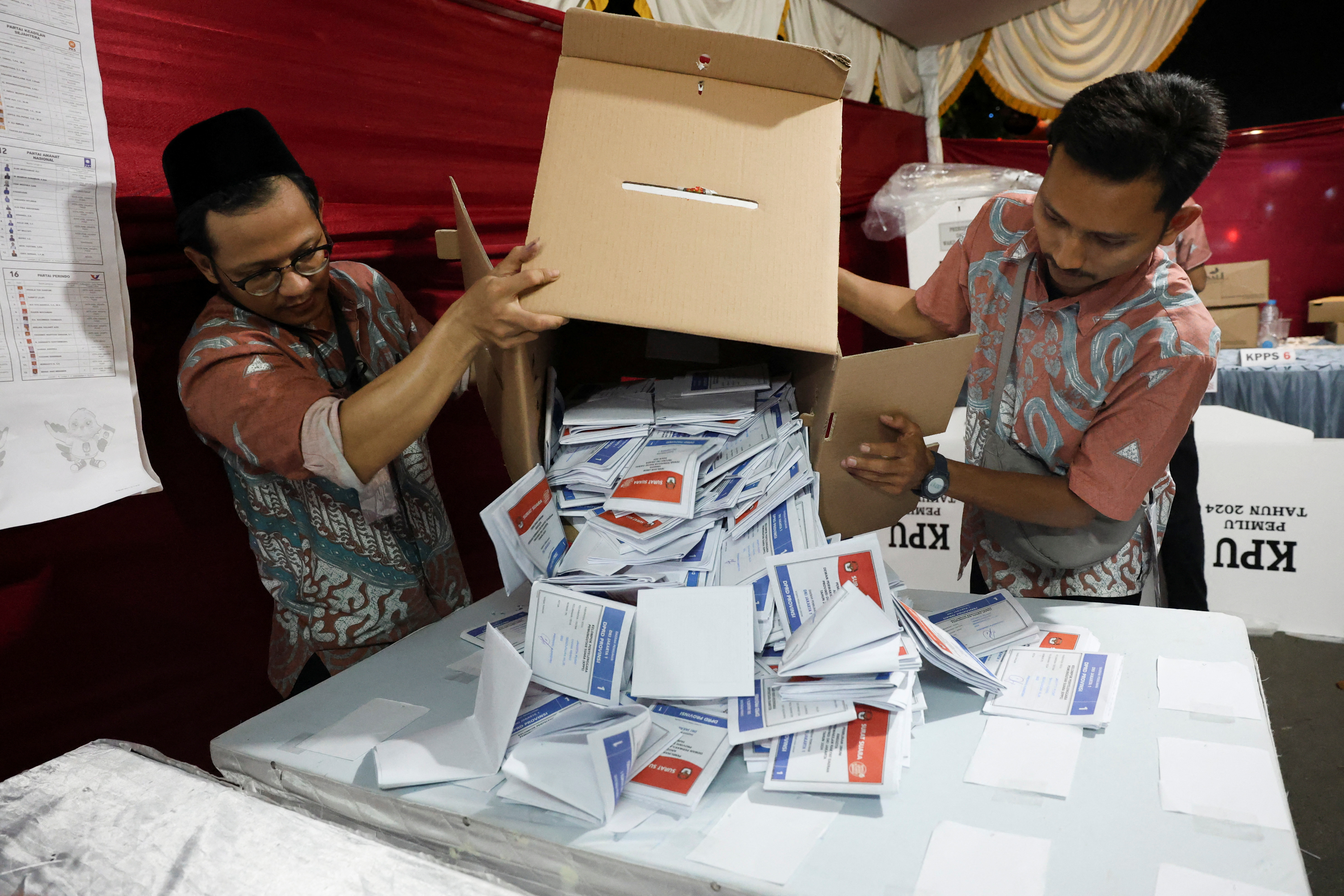 Electoral officers count votes at a polling station after general election polls closed in Jakarta