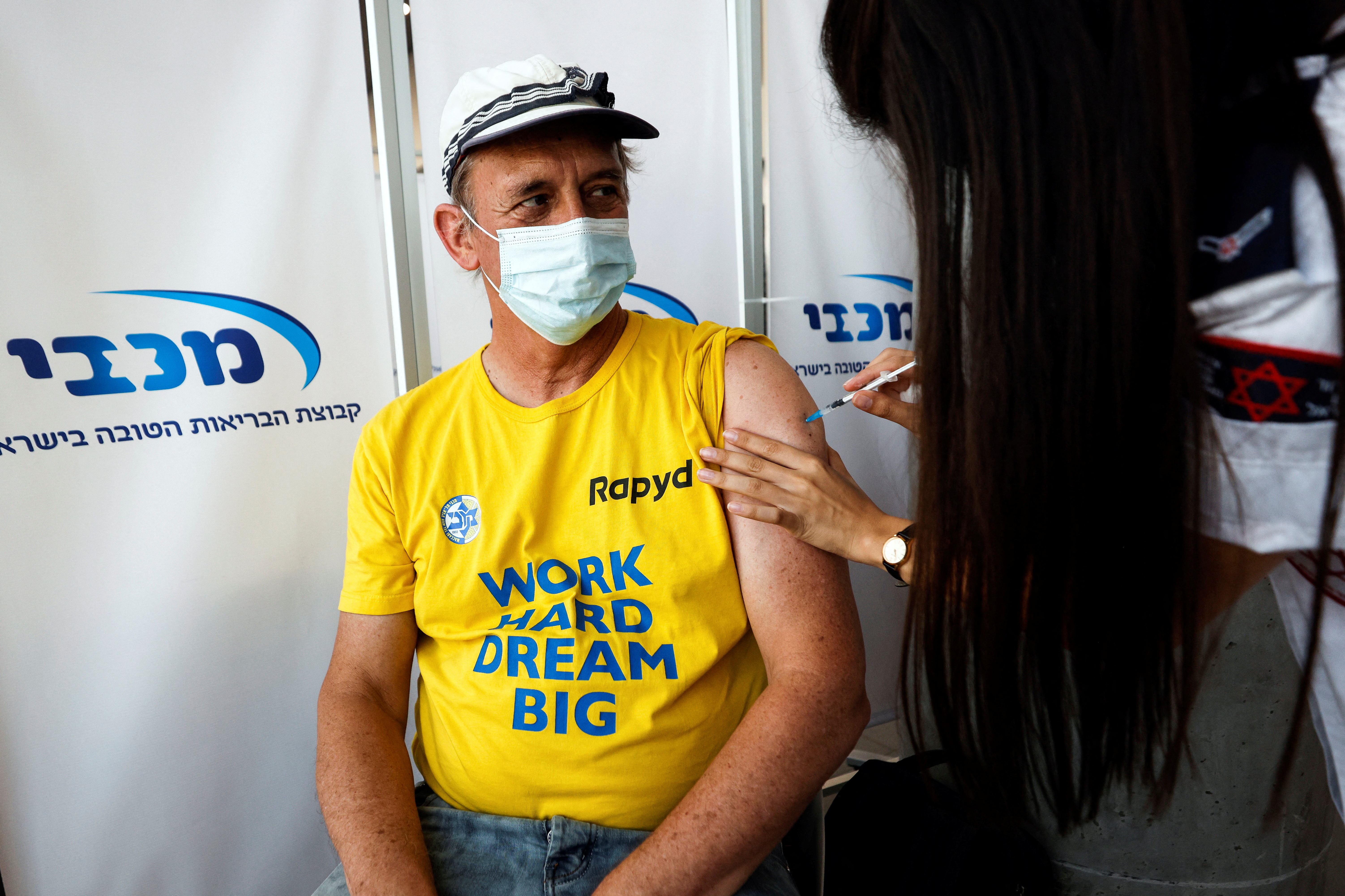 An Israeli man receives a third shot of coronavirus disease (COVID-19) vaccine in Tel Aviv