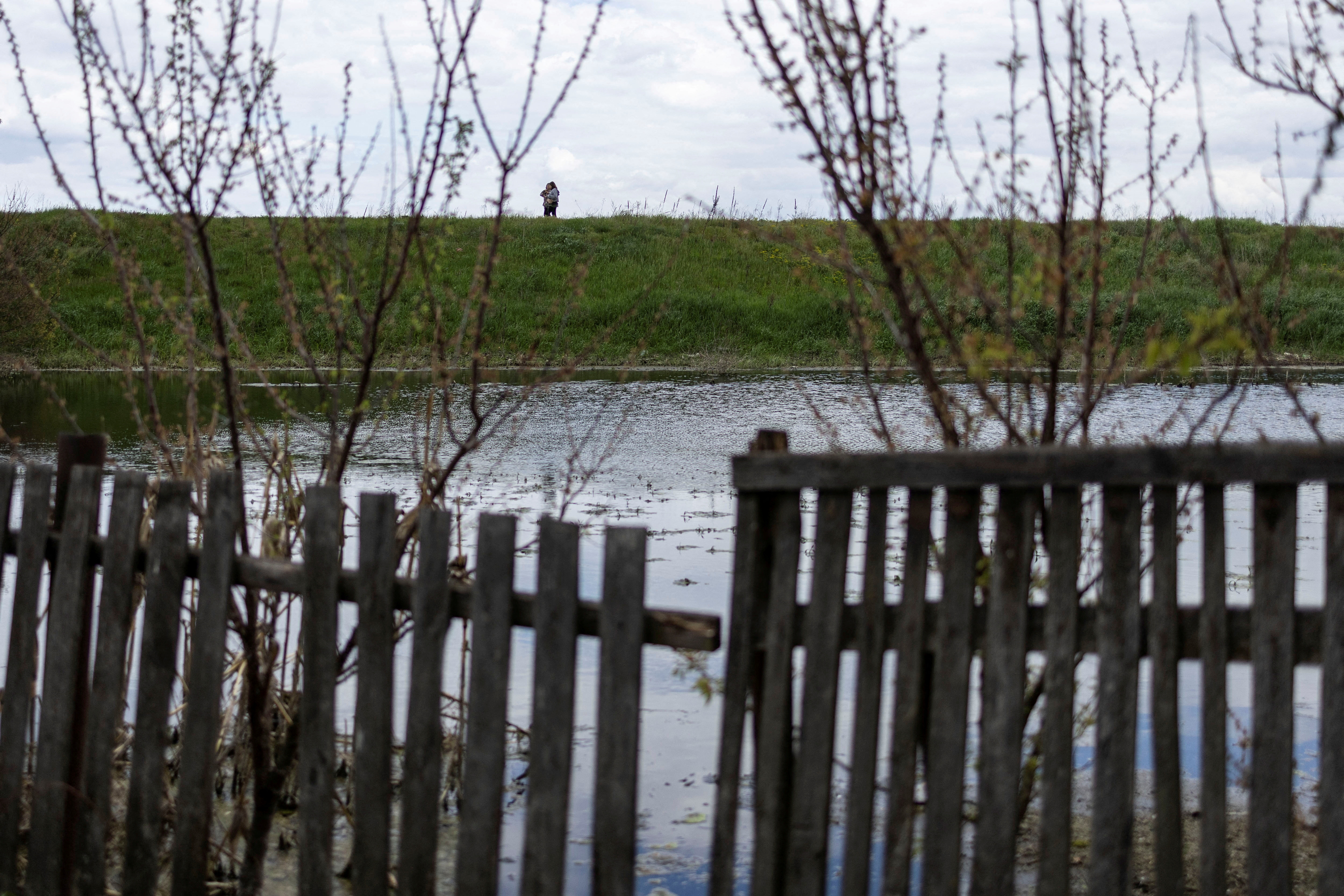 Local residents walks along a flooded area after Ukrainian military forces opened a dam to flood an residencial area in order to stop advance of Russian forces to arrive to the capital city of Kyiv, in Demydiv,