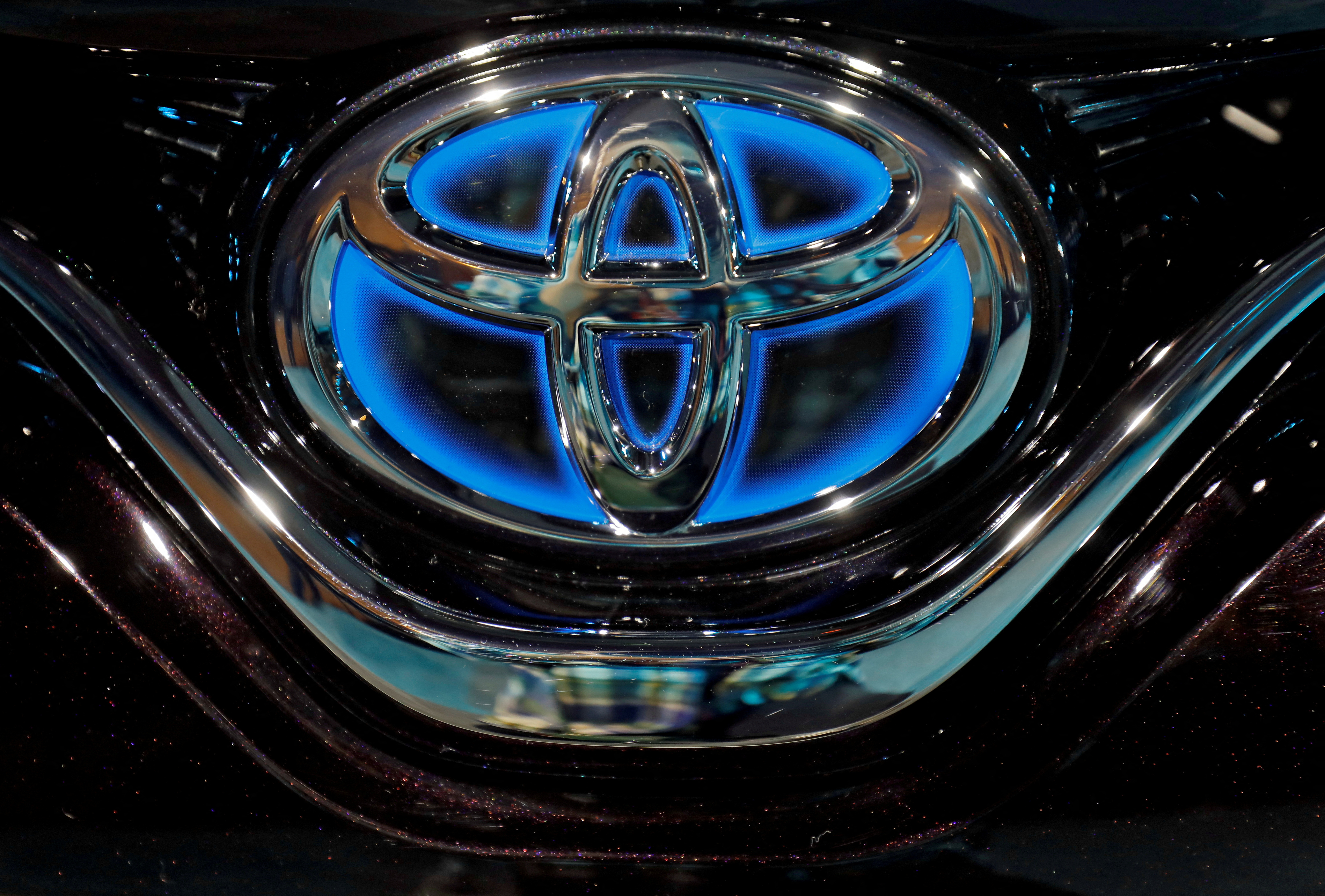The Toyota logo is seen on a Camry Hybrid electric vehicle in New Delhi