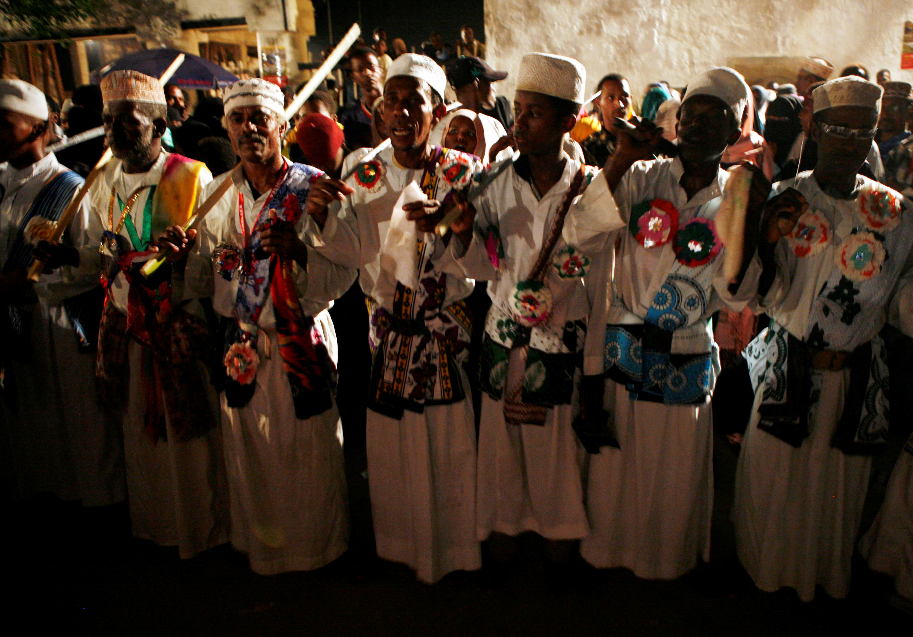 Local men sing and dance during a mock traditional Swahili wedding in Lamu