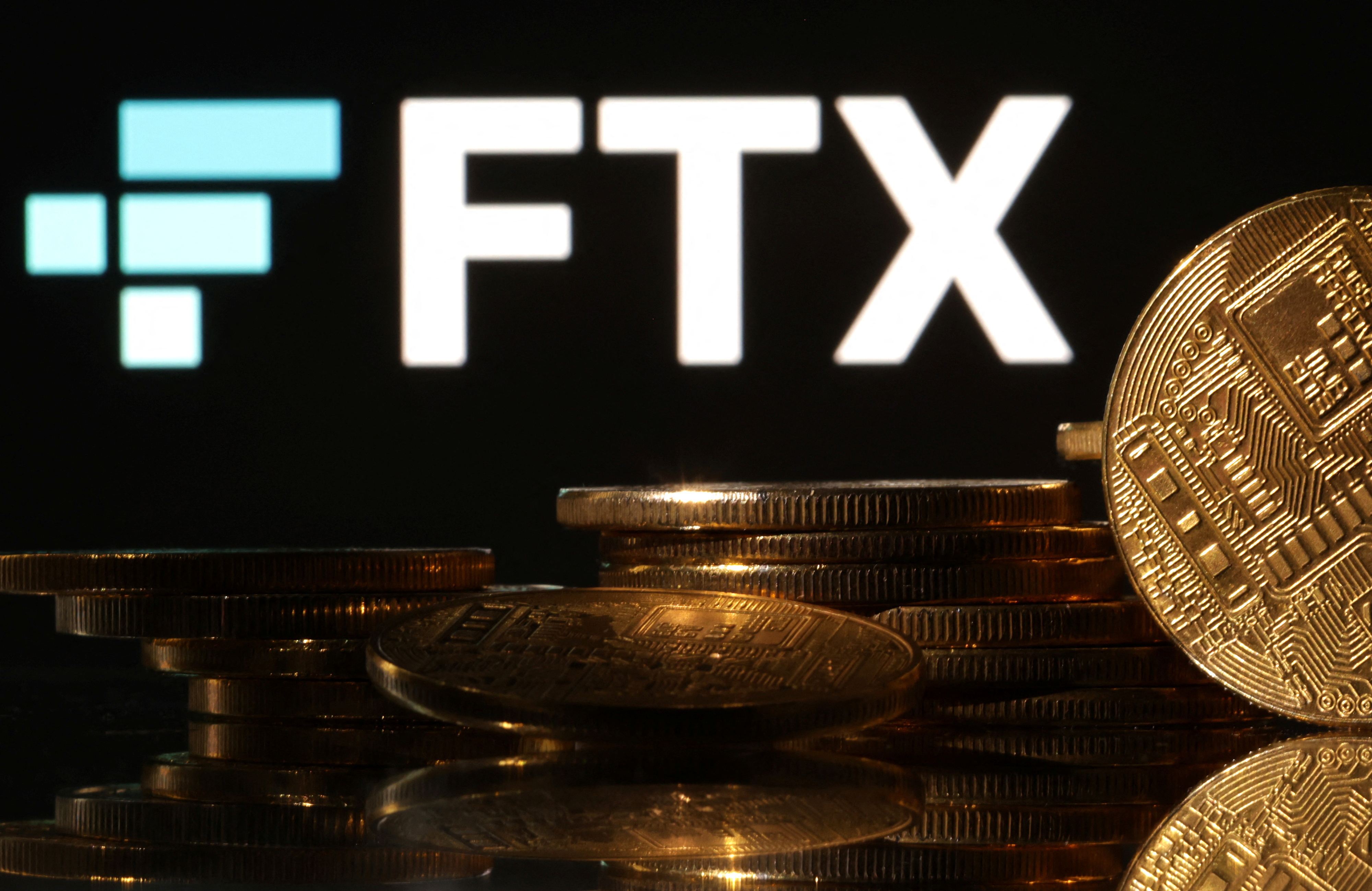 Image shows FTX logo and display of cryptocurrencies