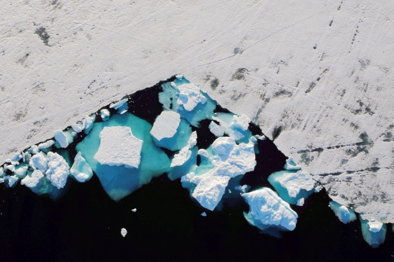 An iceberg floats in a fjord near the town of Tasiilaq