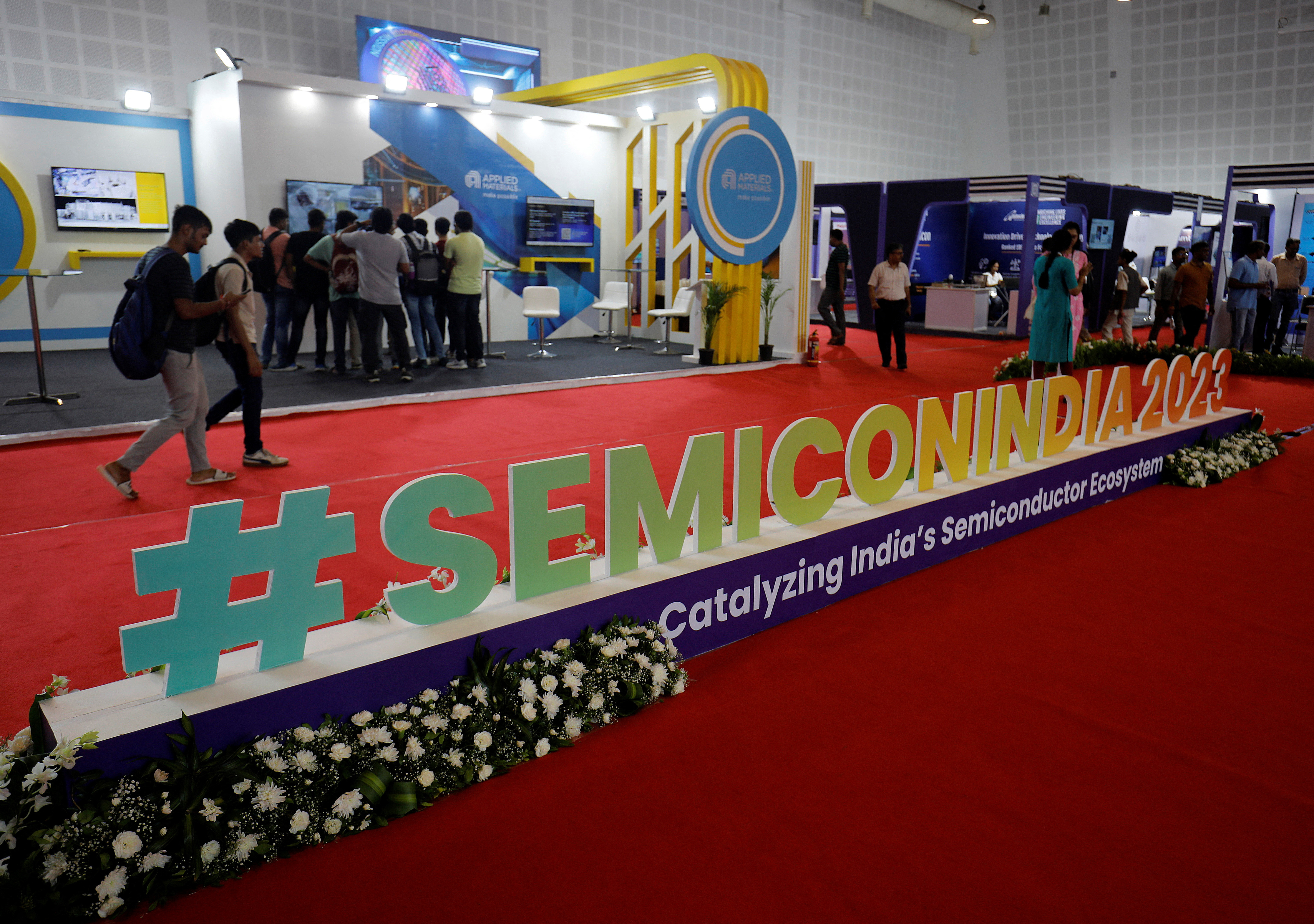 Visitors gather at Applied Materials and Micron Technology kiosks before the start of 'SemiconIndia 2023' in Gandhinagar