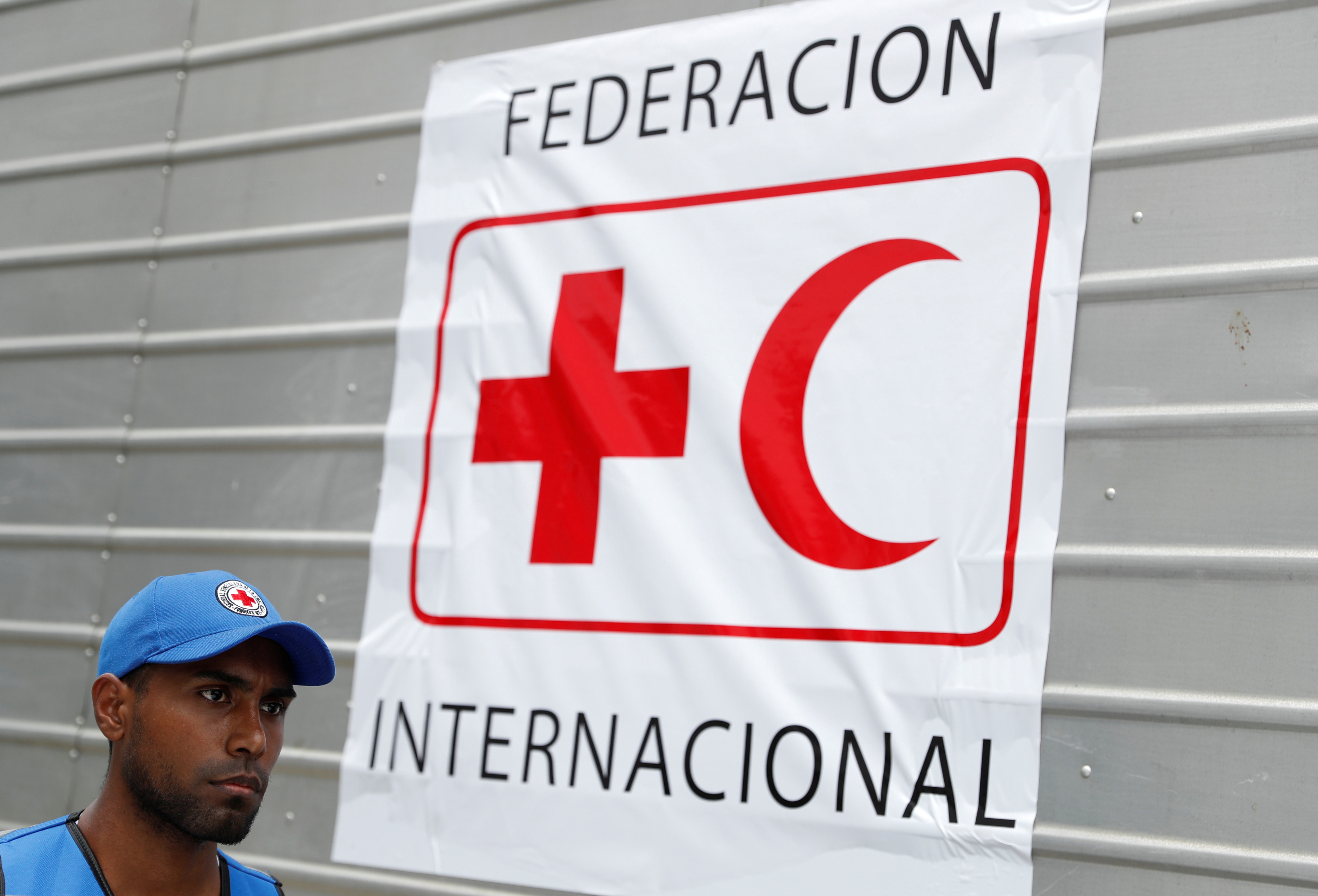 A worker of Venezuelan Red Cross walks past a truck with logo of the International Federation of Red Cross and Red Crescent Societies (IFRC) carrying humanitarian aid, at a warehouse where the aid will be stored, in Caracas
