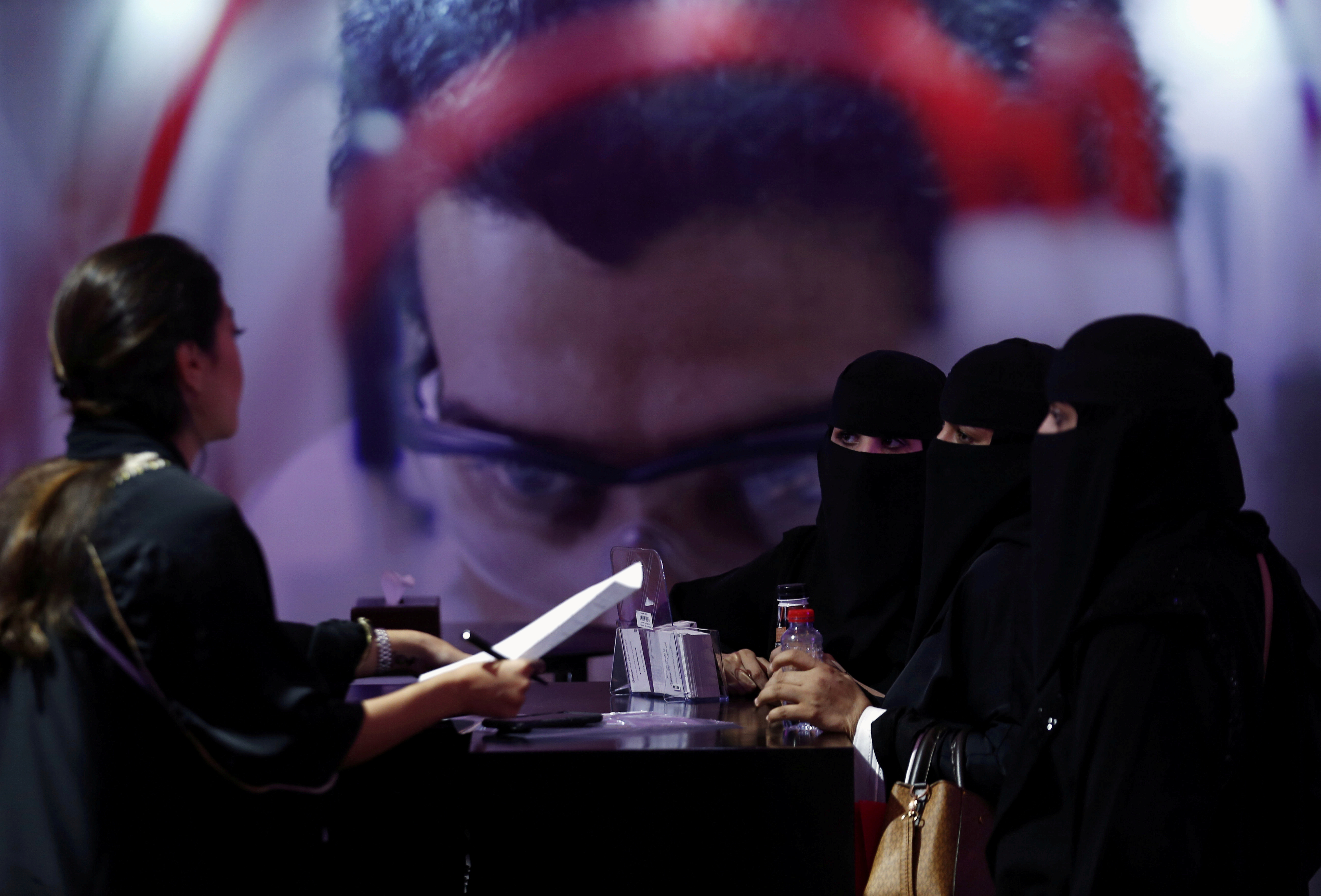 Saudi job seekers talk to a company representative at Glowork Women's Career Fair in Riyadh